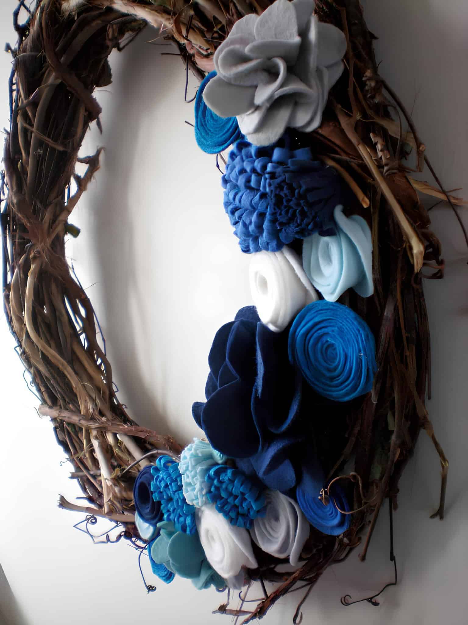 Handmade wooden grapevine wreath embellished with blue and white felt flowers