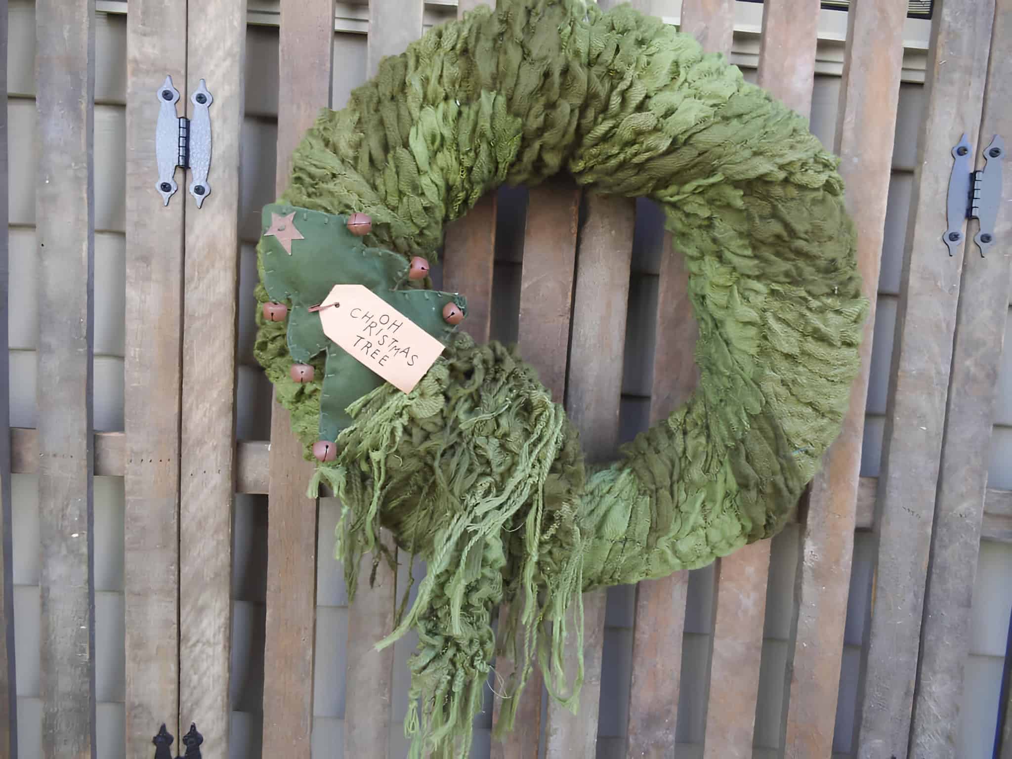 Green fabric Christmas wreath with tree tag and rustic bells