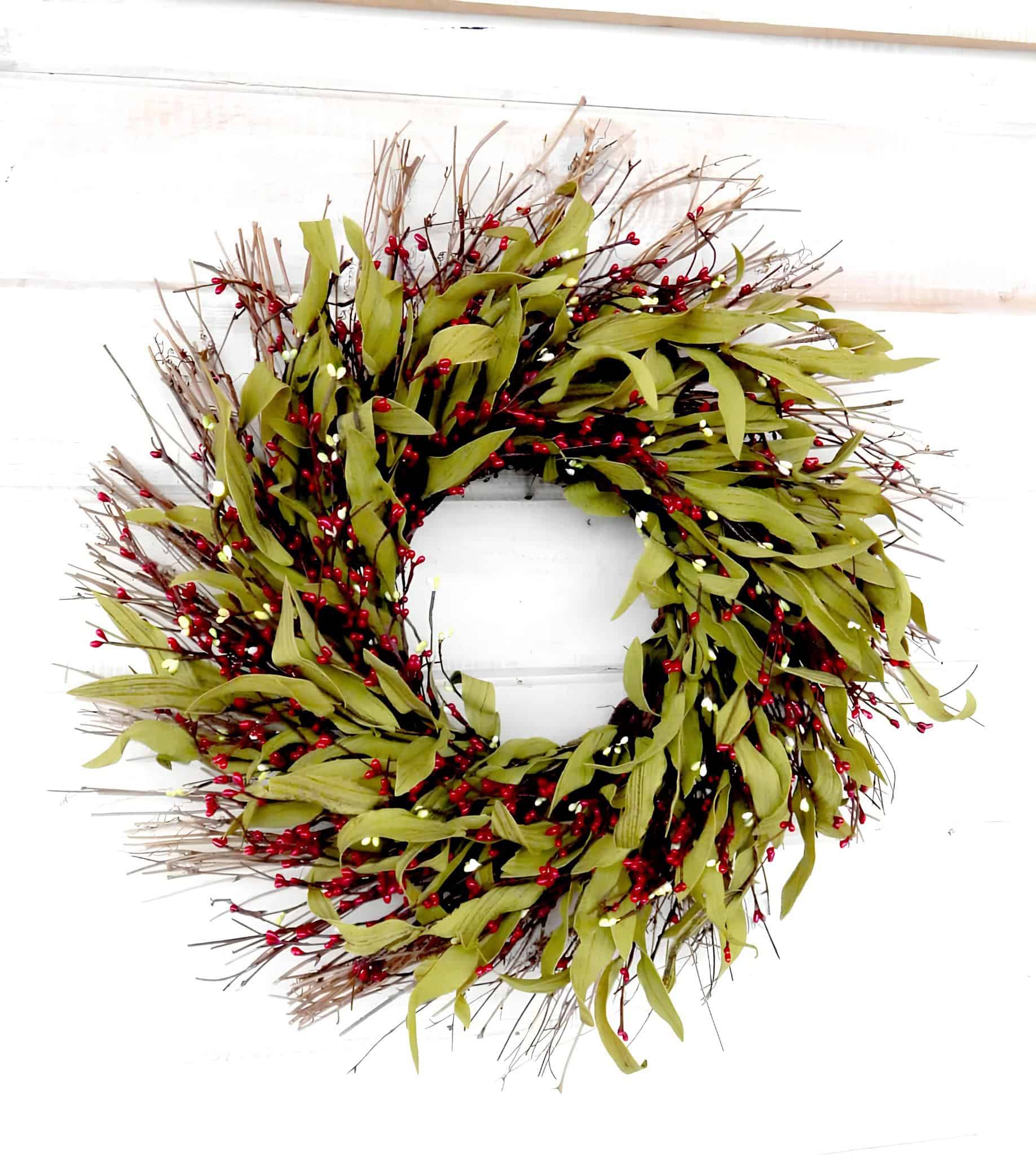 Natural Christmas wreath made of twigs, red berries and green leaves