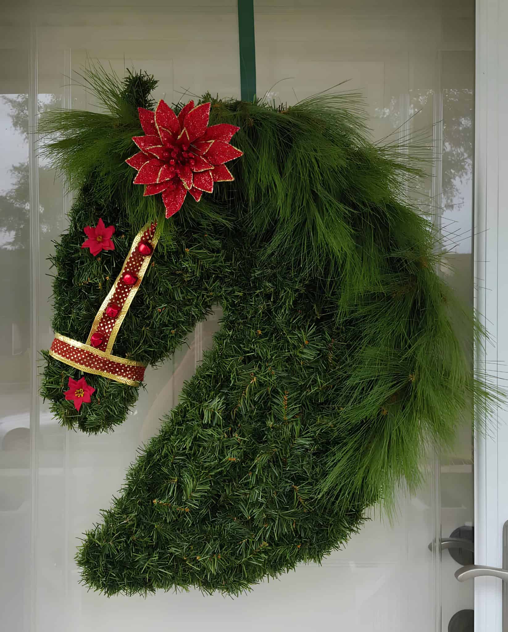 Unique horse head shaped Christmas wreath with red poinsettia flowers and pine greenery