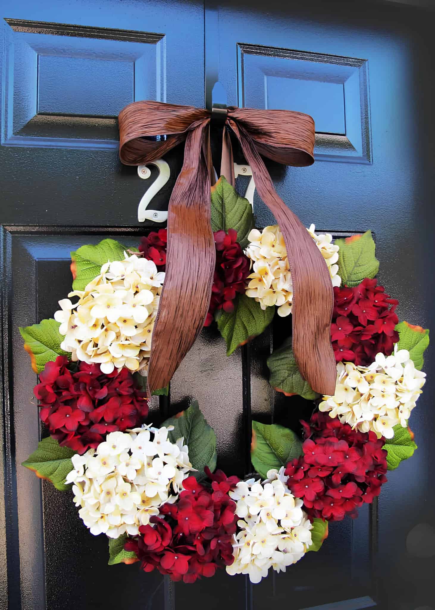 Classic Christmas wreath with cream and burgundy hydrangeas and a wide brown ribbon