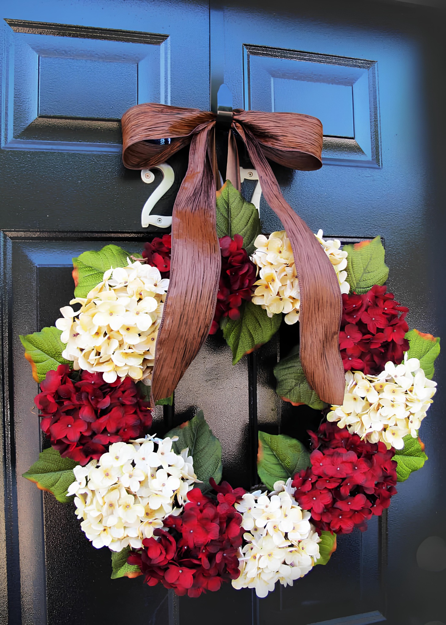 Hydrangea Christmas wreath in red and white with a wide brown ribbon bow