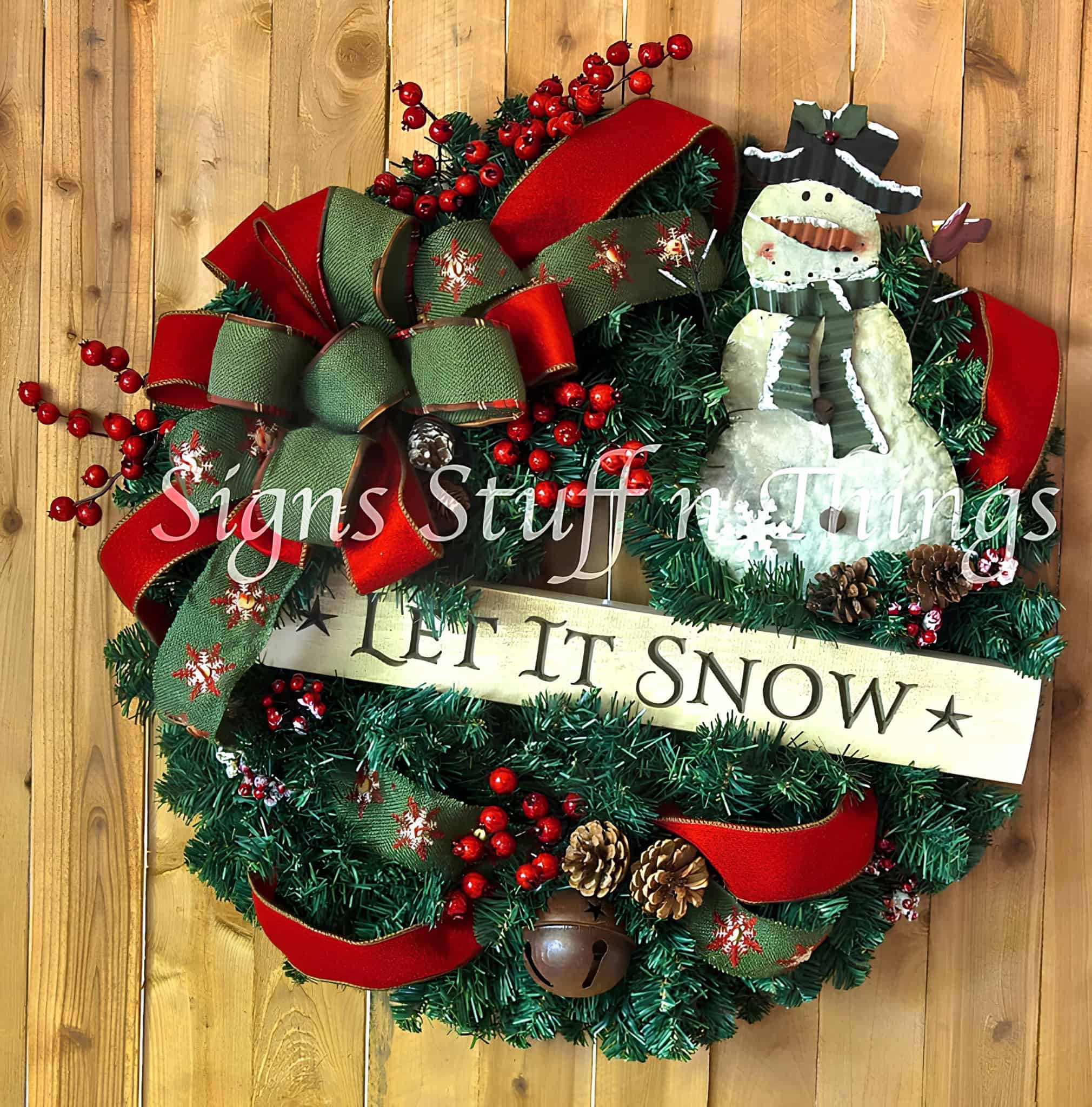 Evergreen ribbon wreath with green and red bow, red berries and rustic snowman
