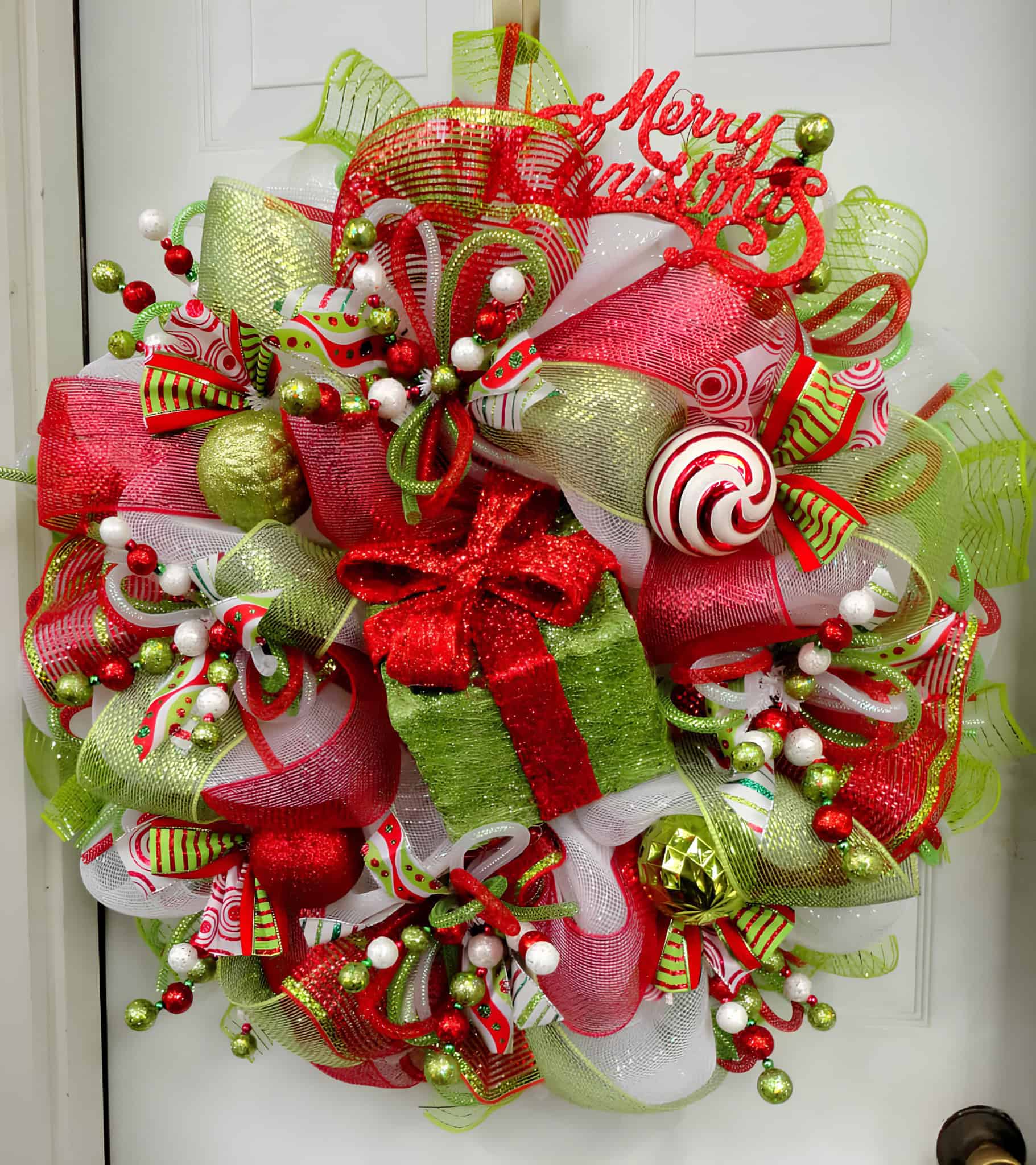 Vibrant ribbon wreath with lime green and red present centerpiece