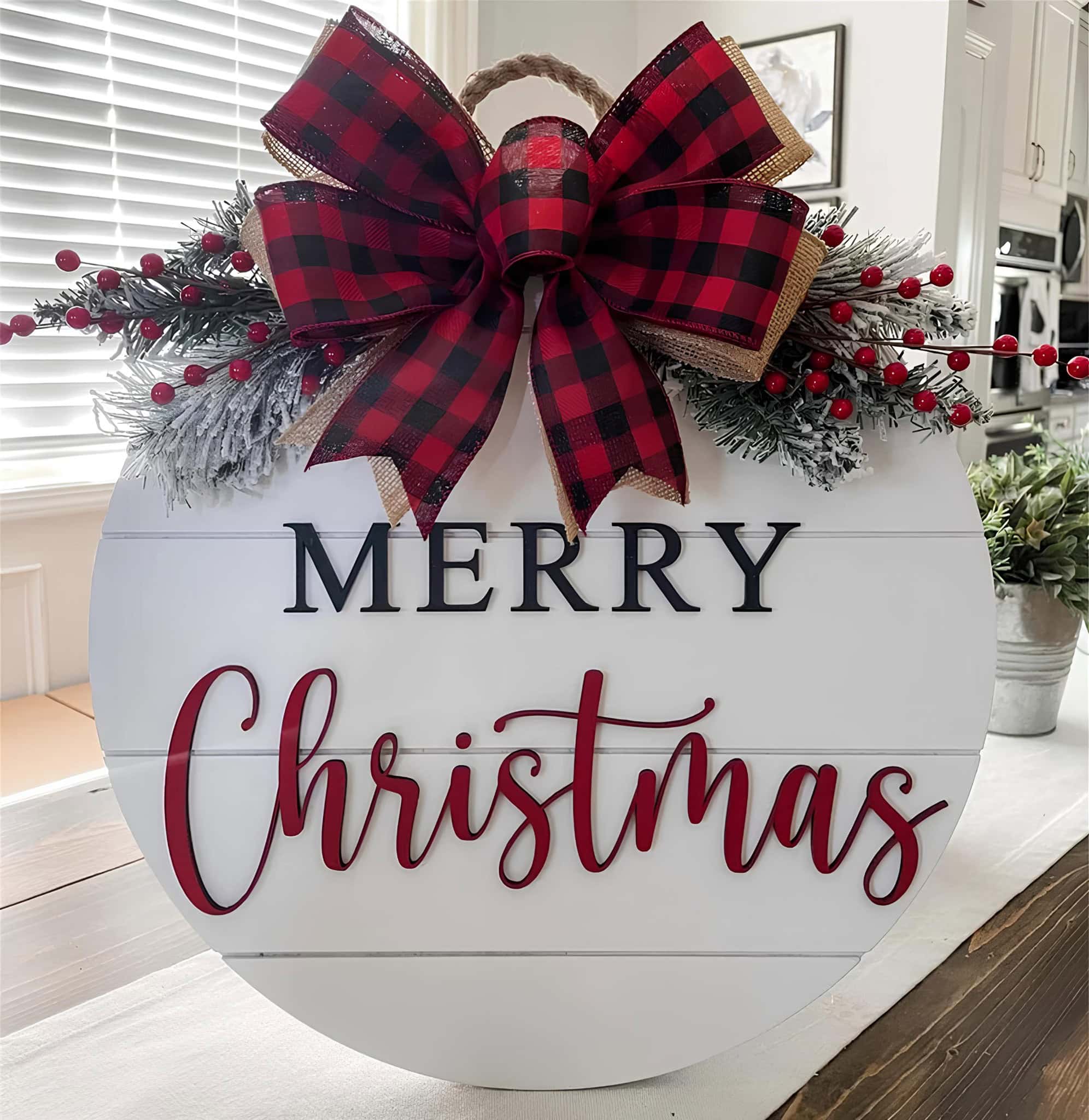 Round Merry Christmas door sign with buffalo plaid bow and frosted greenery