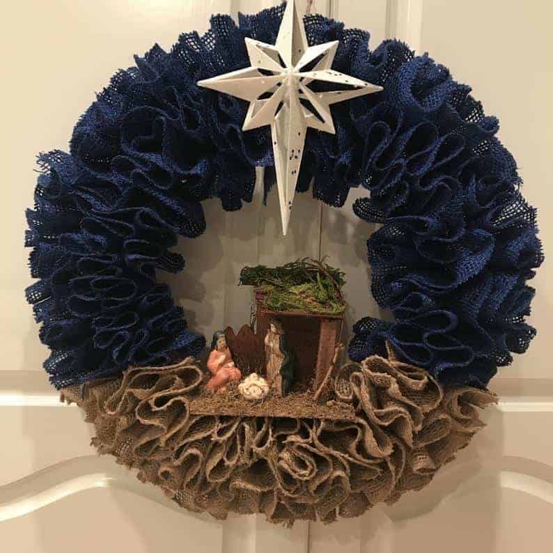 Rustic burlap Christmas wreath with nativity scene and white star topper