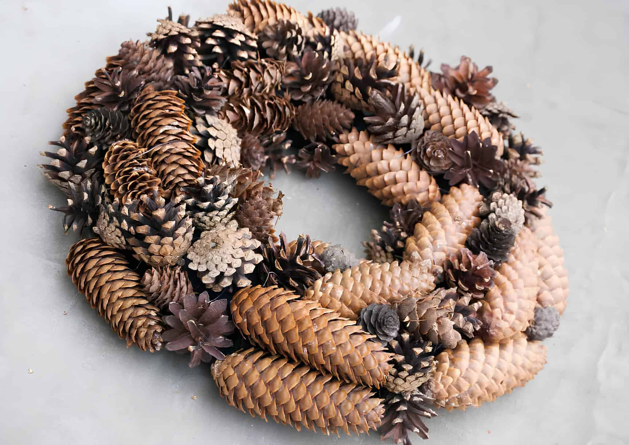 Minimalist Christmas wreath made entirely of assorted pinecones