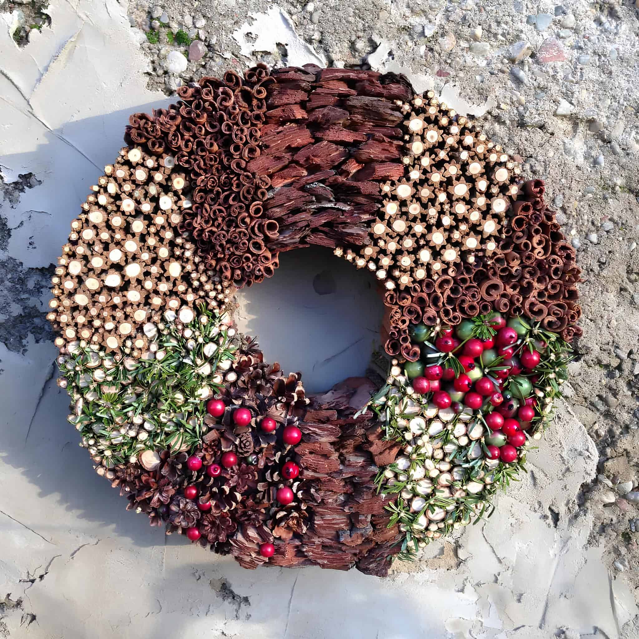 Handmade natural wreath with bark, berries, pinecones, and dried wood slices