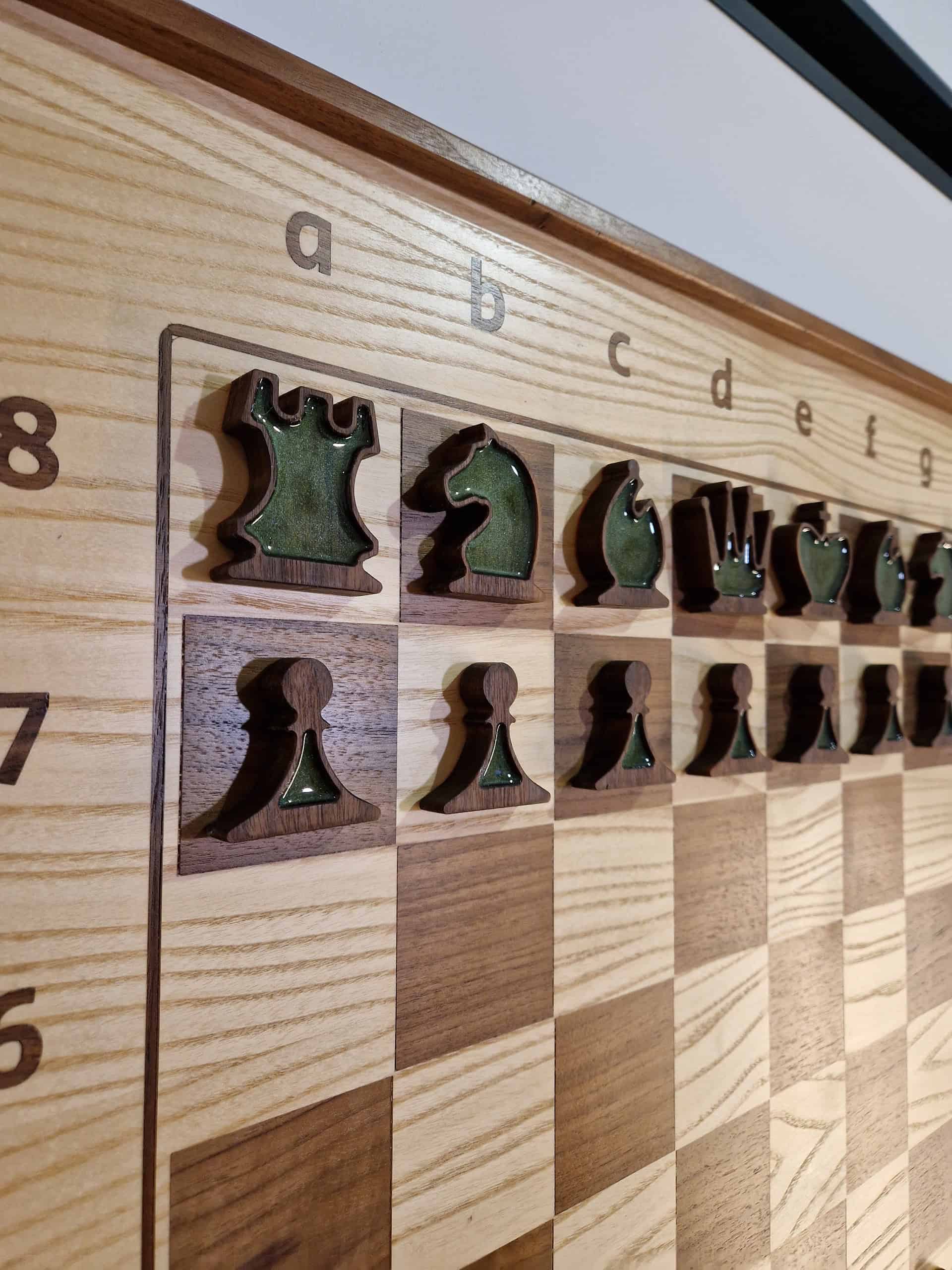 Close-up of a ChessboArt vertical wall chess set, featuring hand-carved green and brown chess pieces. Showcasing fine woodcraft and artistic detail for modern interiors.
