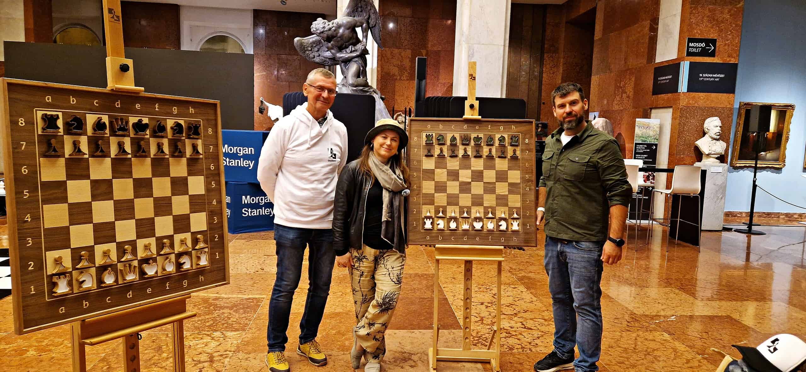 Michał Fudalej (FM) and the ChessboArt artisan discussing a custom-made chess table commission at the Global Chess Festival, highlighting expert craftsmanship and design.

