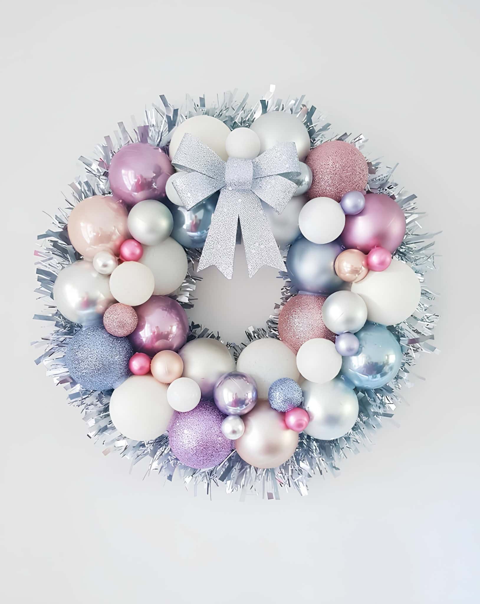 Pastel ornament wreath with tinsel and a silver bow