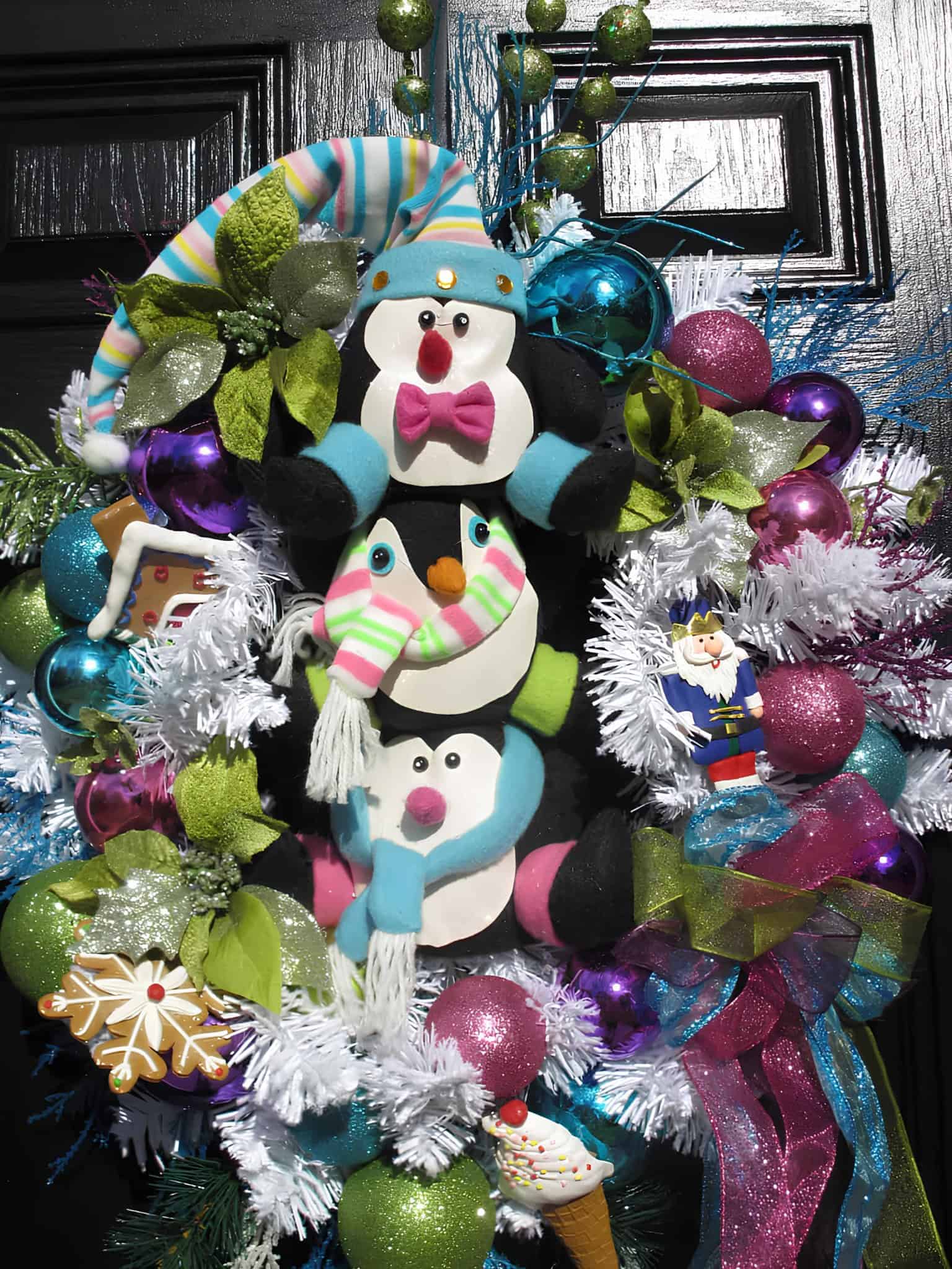 Whimsical penguin Christmas wreath with colorful ornaments and ribbons