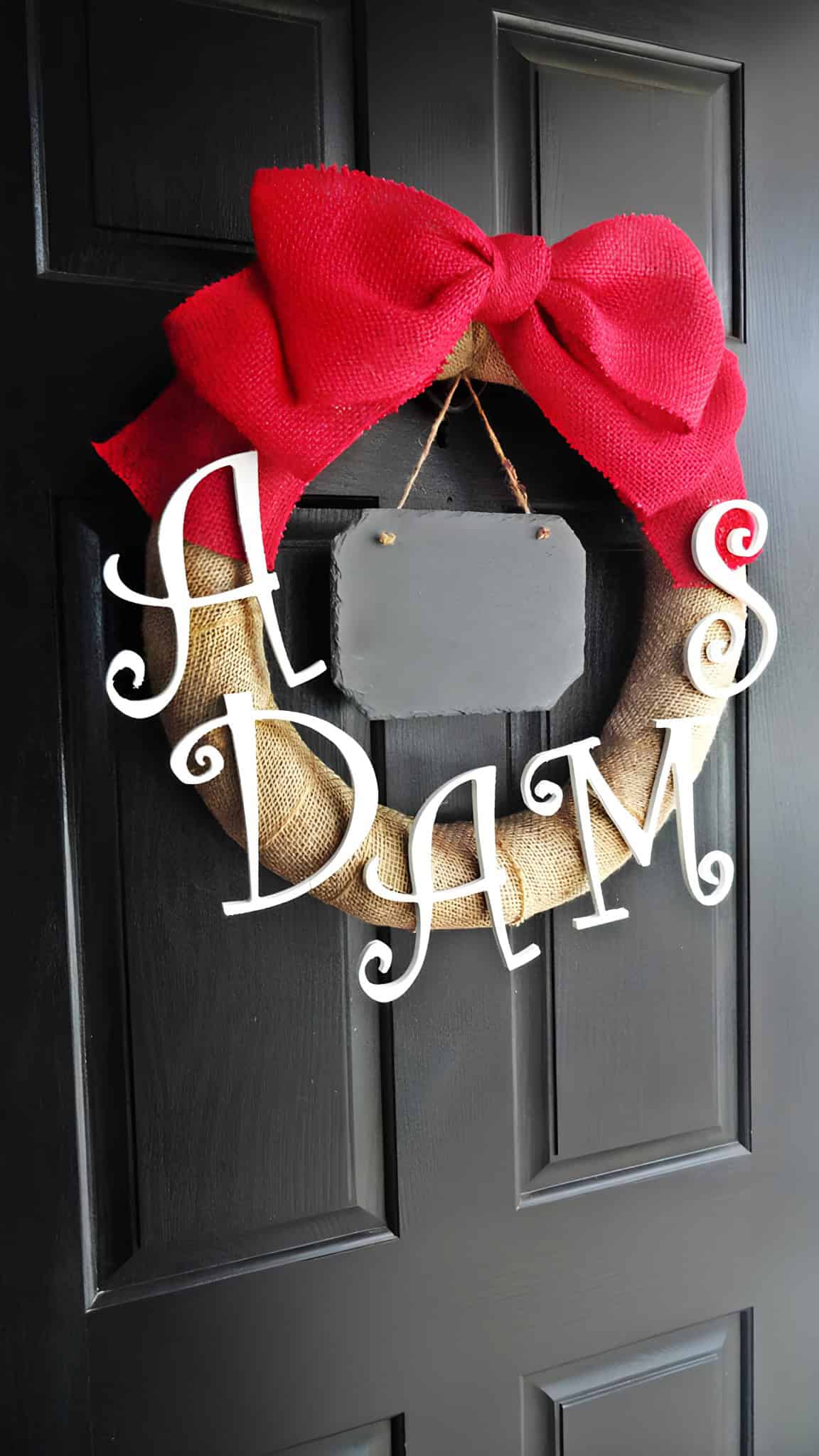 Burlap Christmas wreath with oversized red bow and family name letters