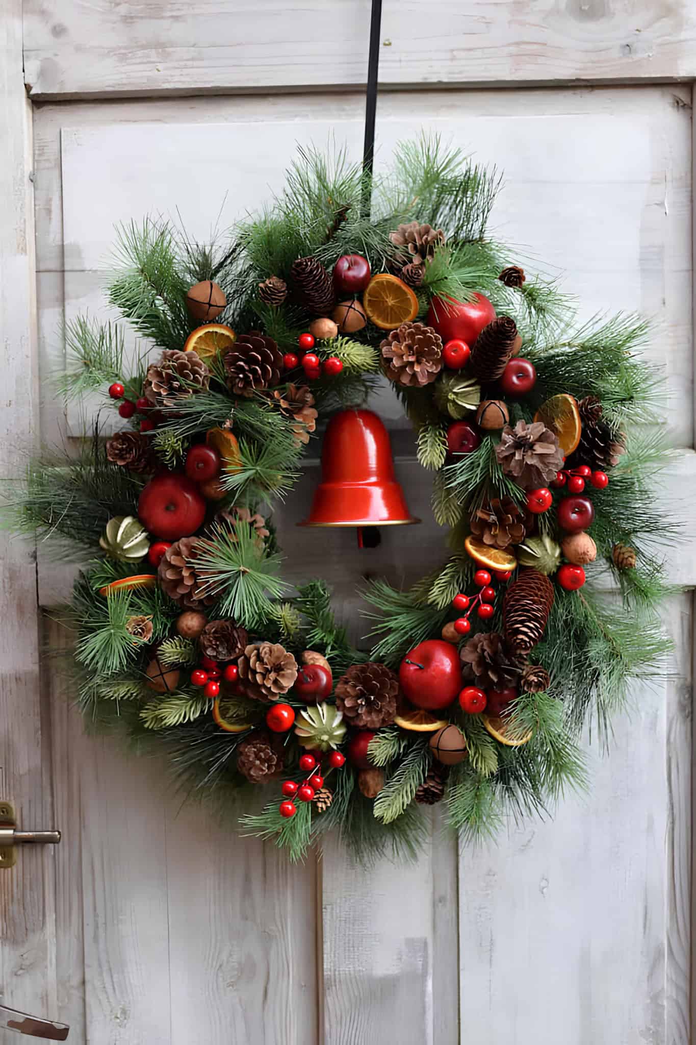 Flocked pine wreath with red berry sprigs for winter