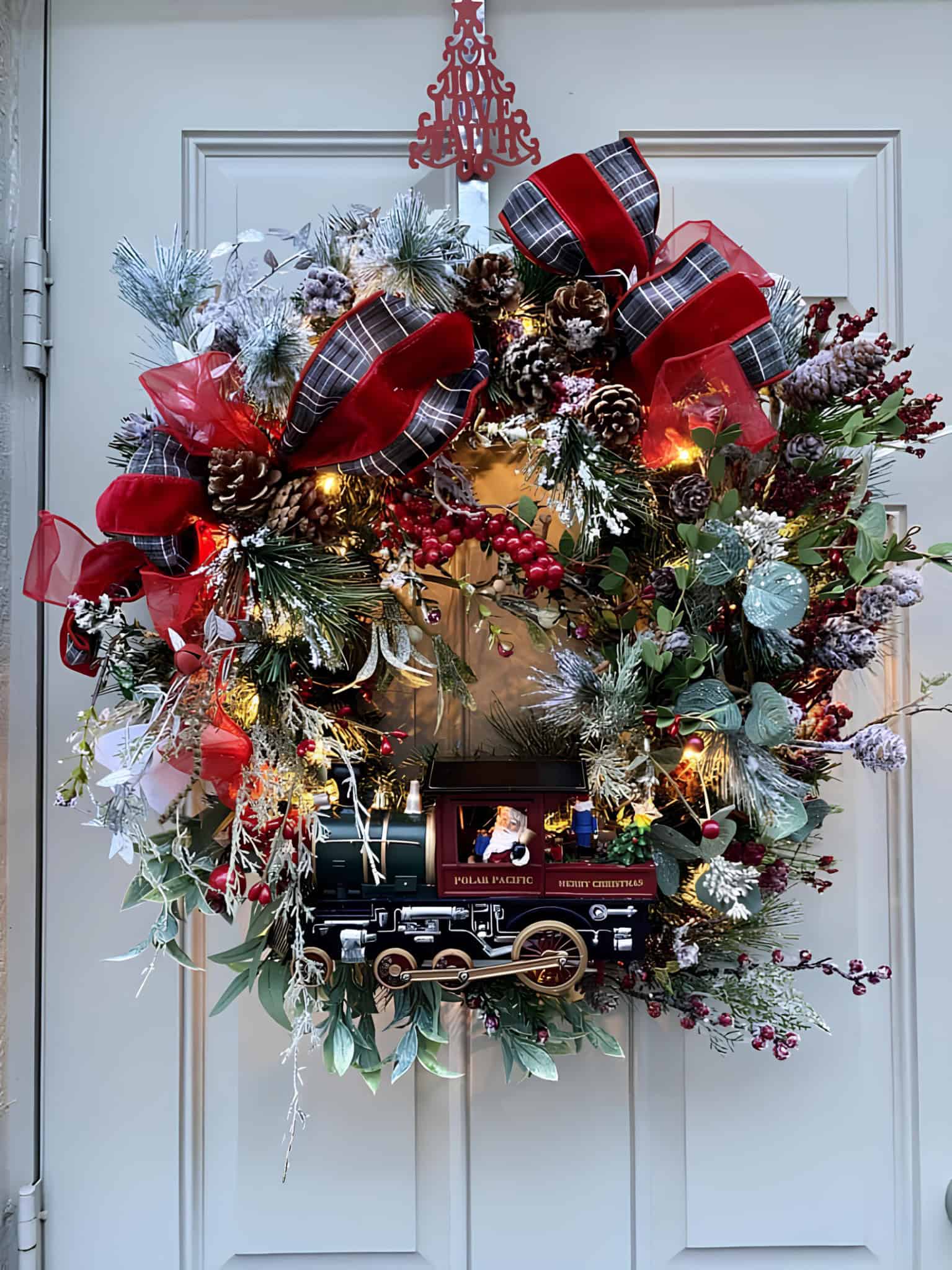Grand Christmas wreath with ribbons, berries and a toy train centerpiece