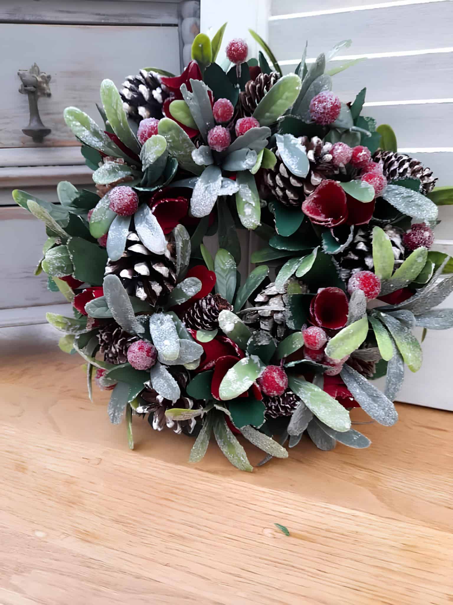 Compact frosted pine wreath with red berries and pinecones