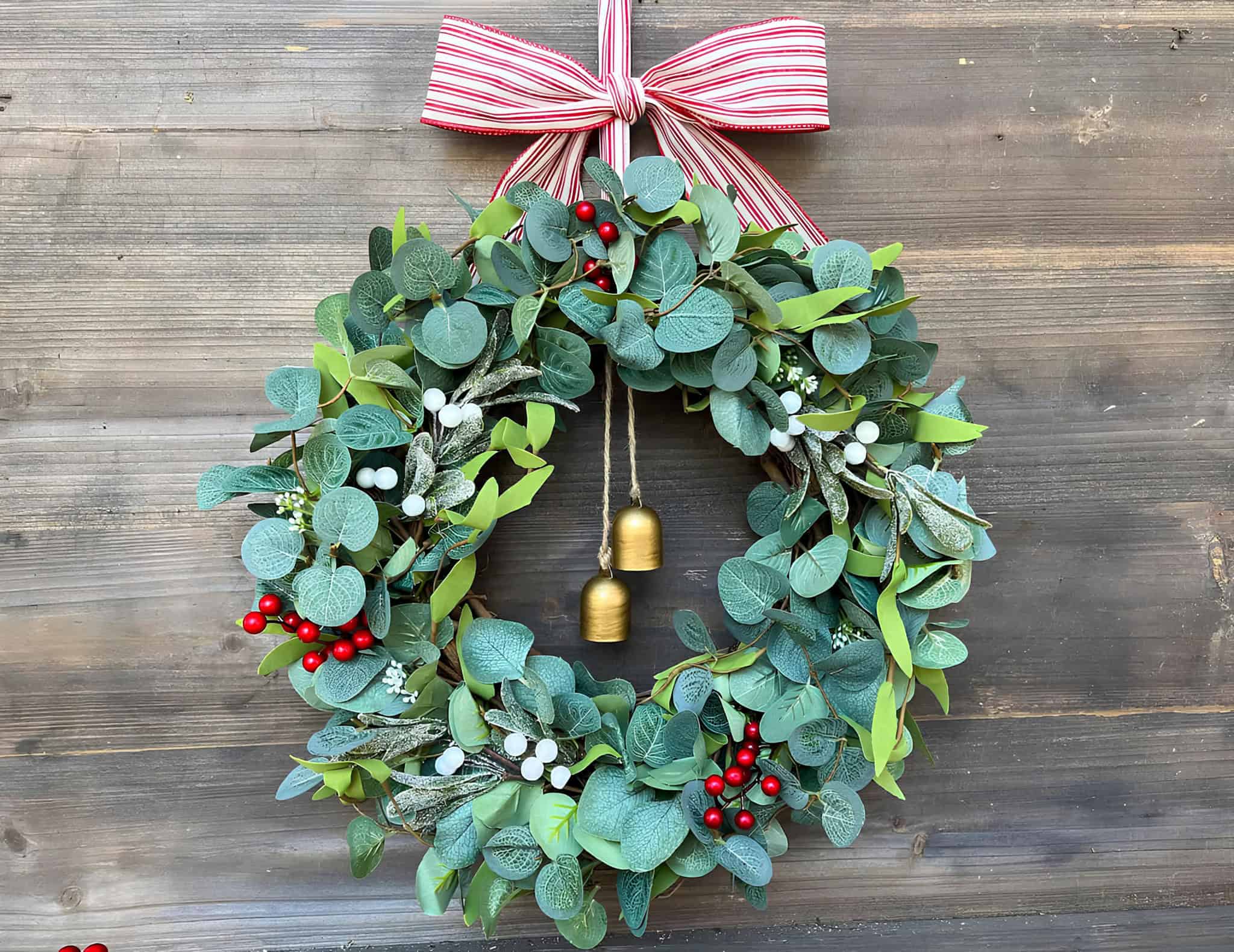 Eucalyptus Christmas wreath with golden bells and red berries