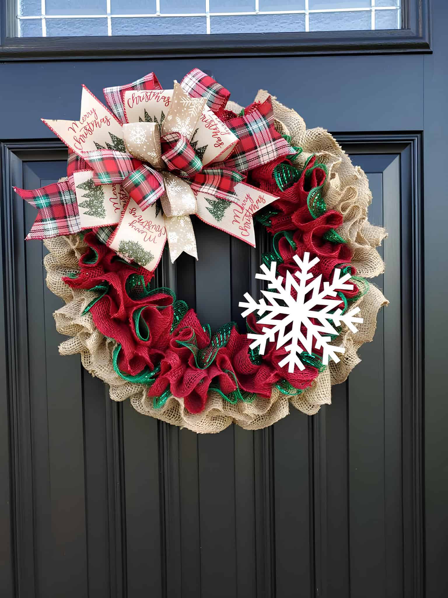 Layered burlap wreath with red and green ruffles, tartan bow and a white snowflake