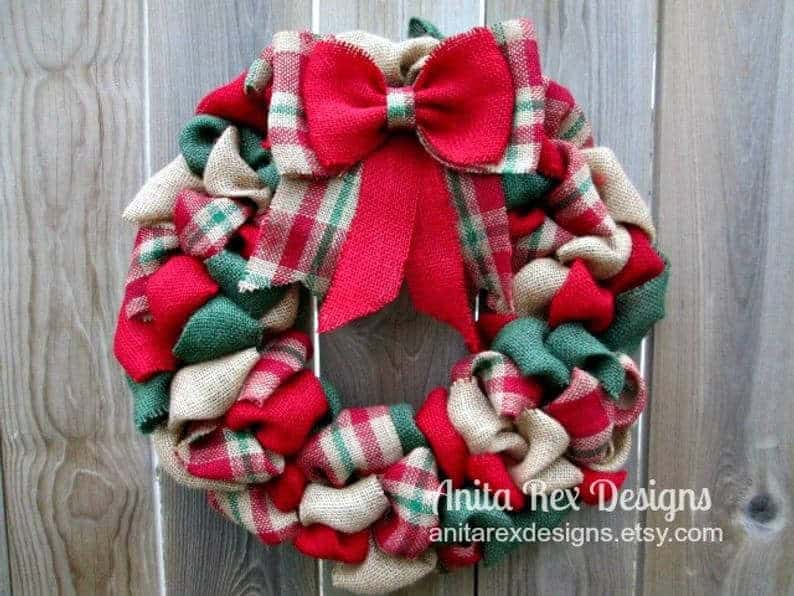 Festive Christmas wreath made of fabric with red, green, and beige plaid patterns, decorated with a large red bow, perfect for holiday home decor.