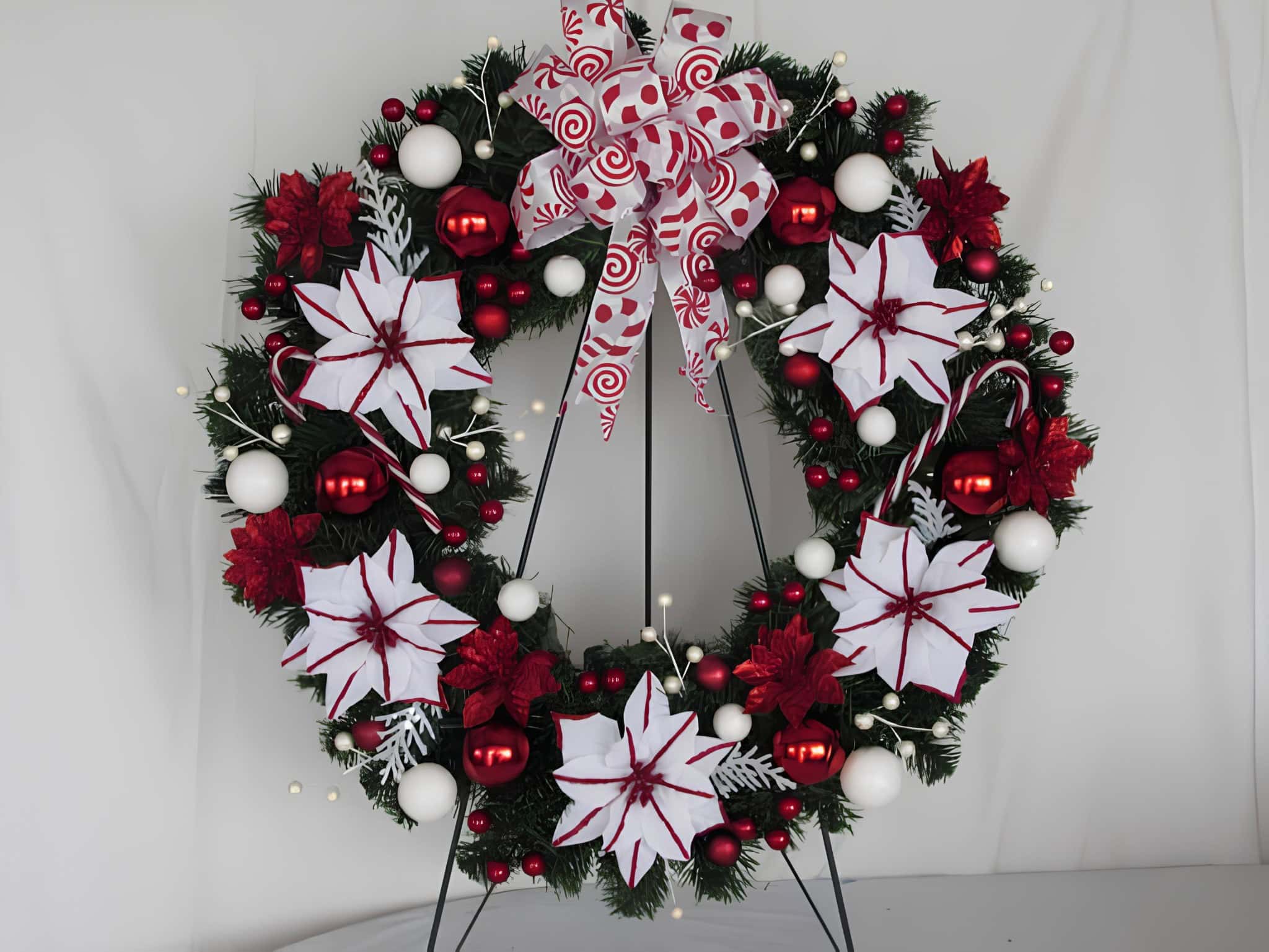 Lantern wreath with poinsettias, candy canes, and red and white ornaments