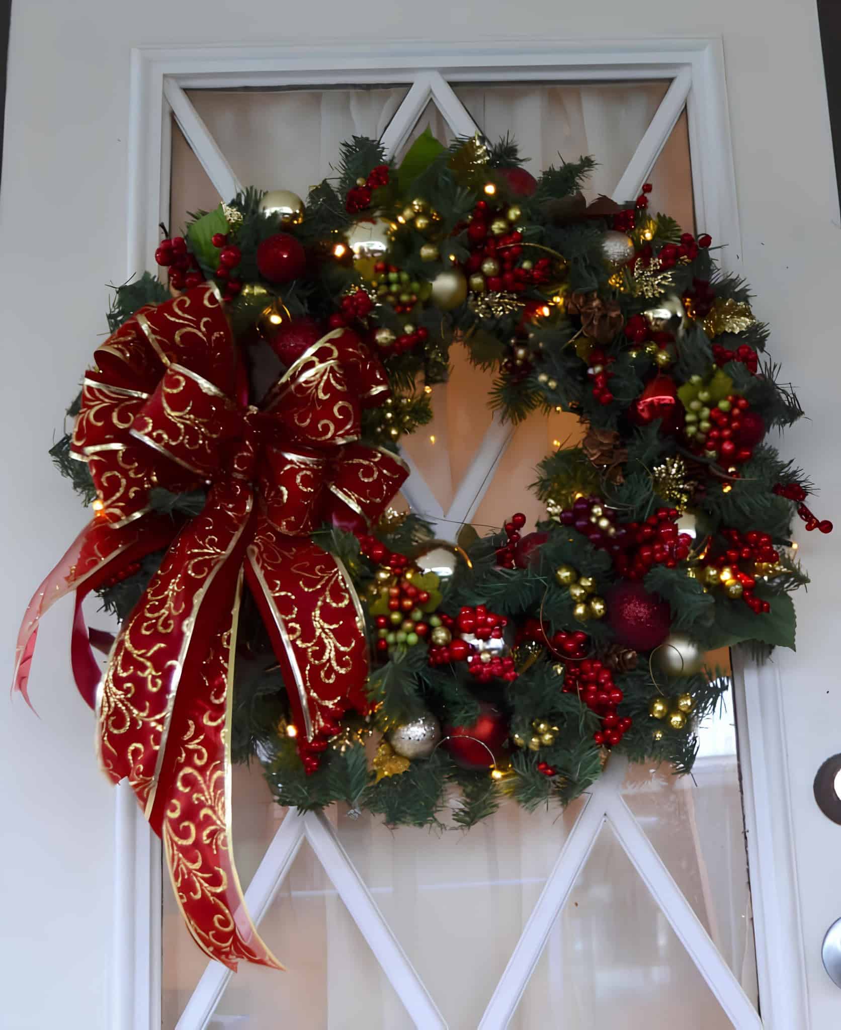 Traditional Christmas wreath with red bow, berries, and lights