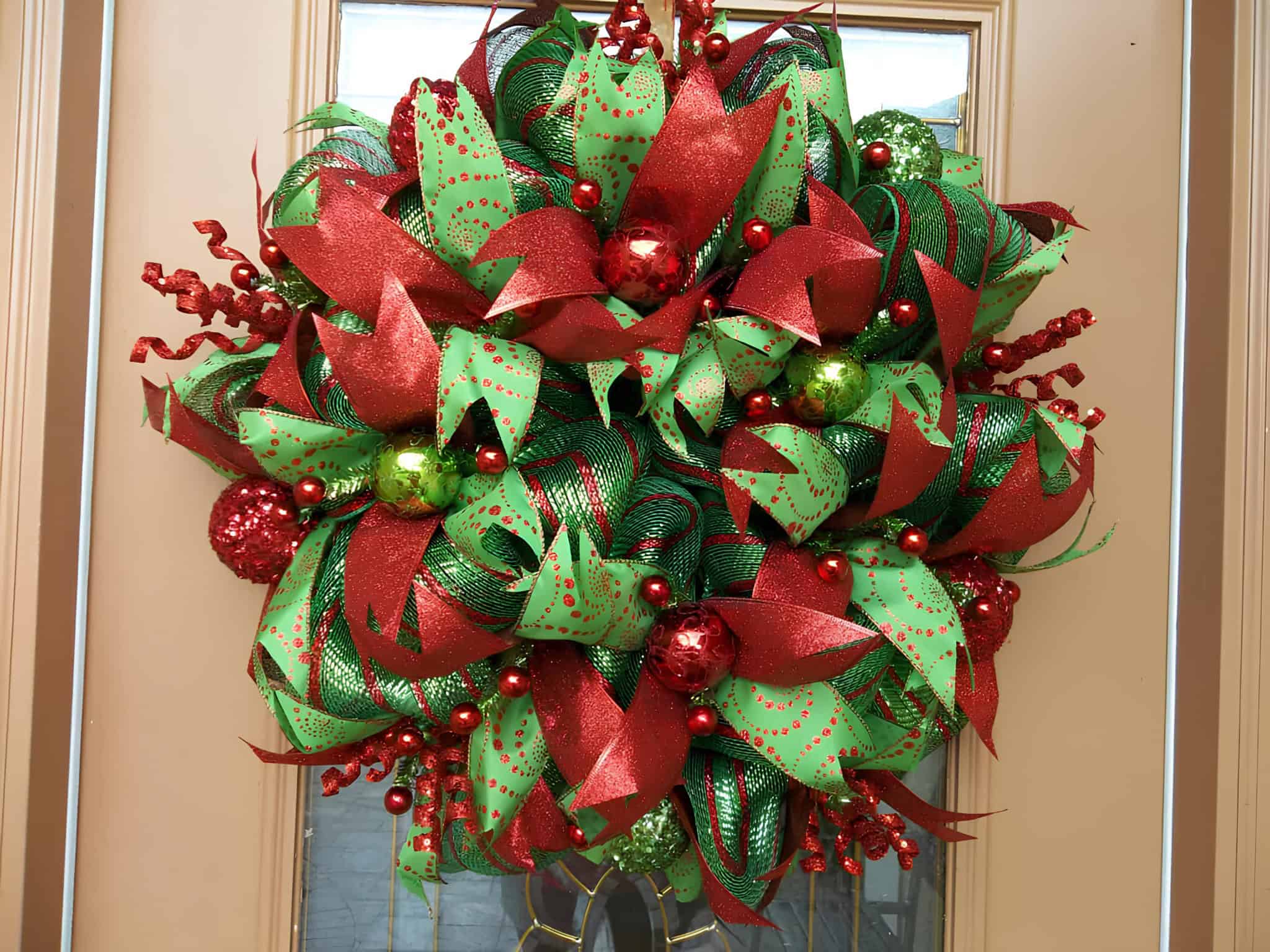 Lush deco mesh wreath in red and green with sparkling bows and ornaments