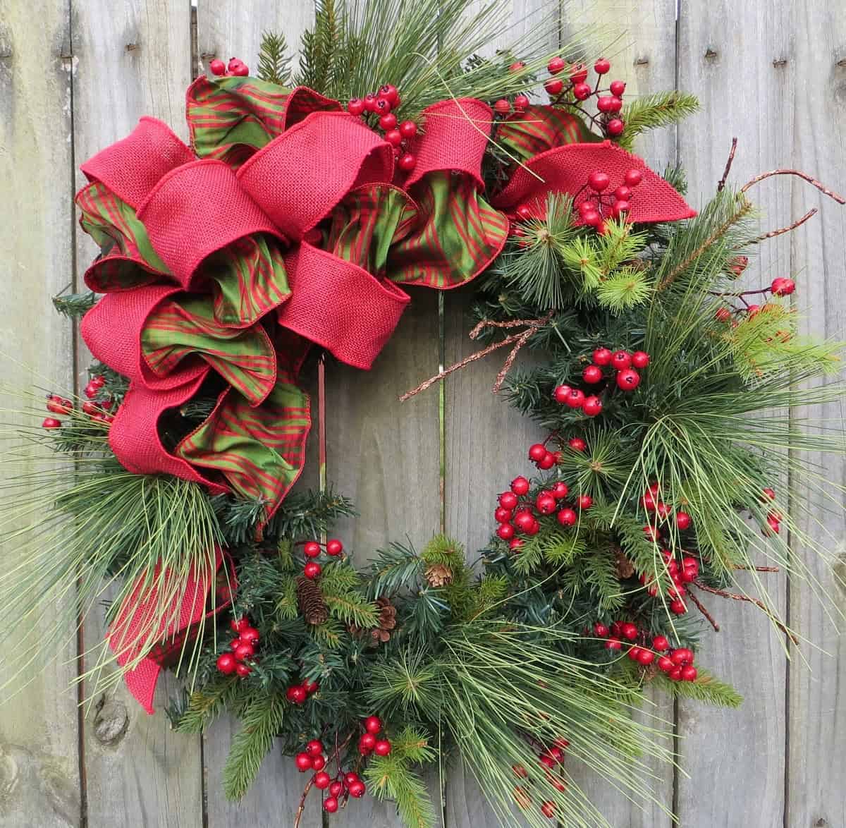Christmas wreath with red and green ribbon and berry clusters