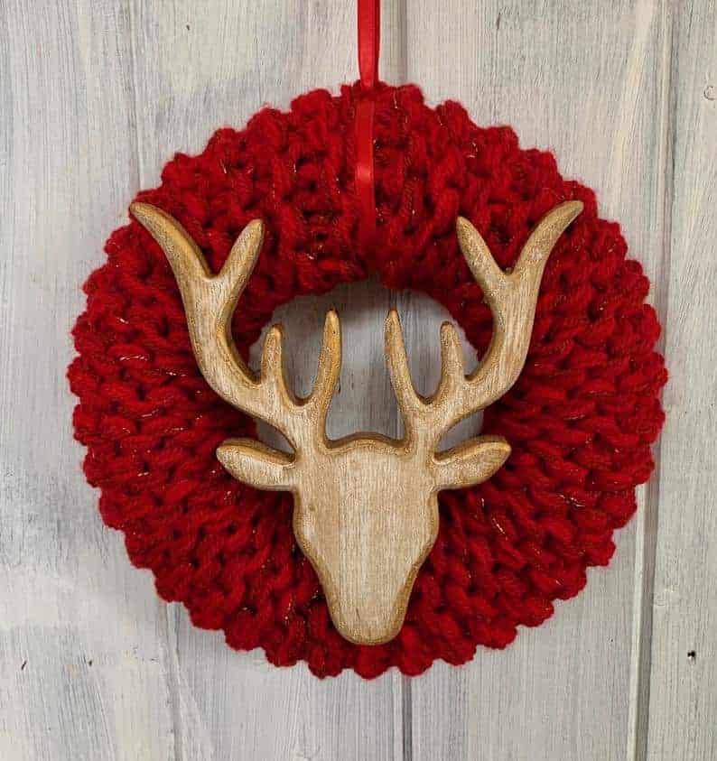 Red knitted Christmas wreath with wooden reindeer ornament