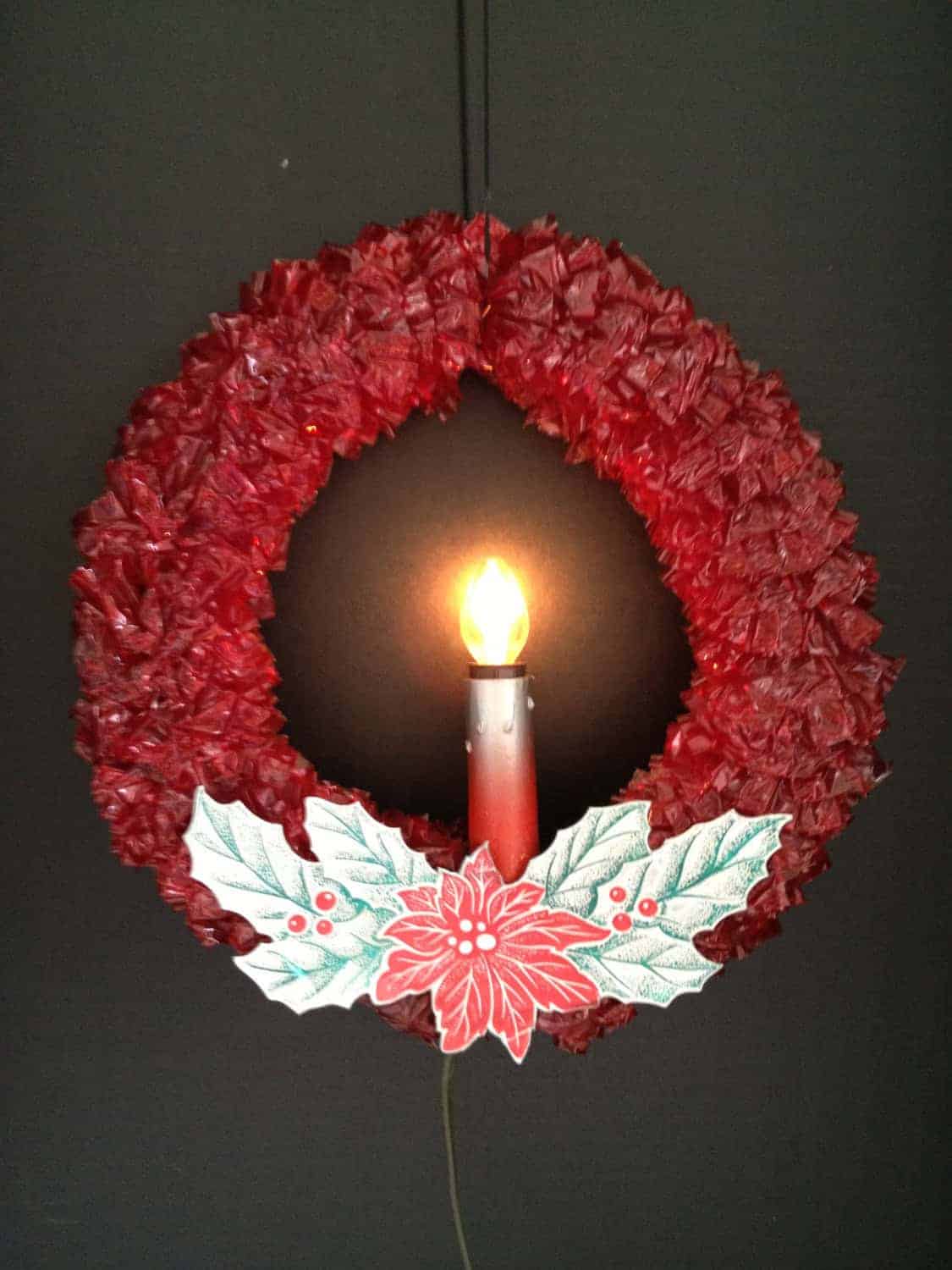 Red paper wreath with center light and holly design