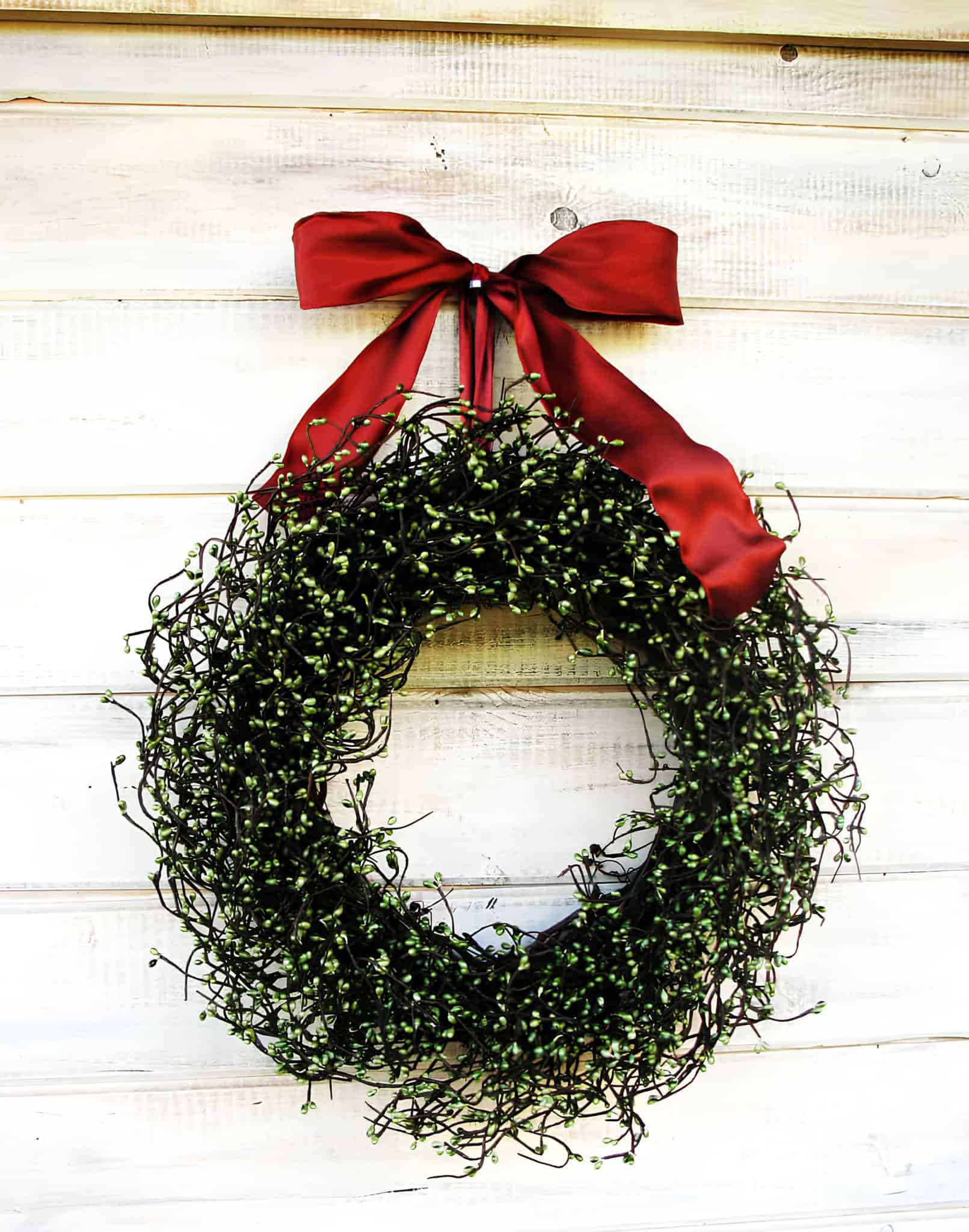 Minimal twig Christmas wreath with greenery and a red satin bow