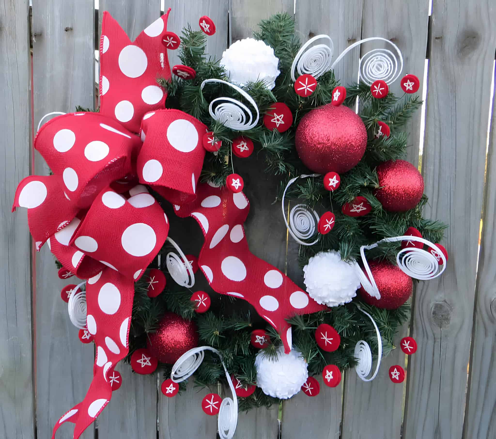 Red ribbon wreath with large white polka dot bow and red ornaments