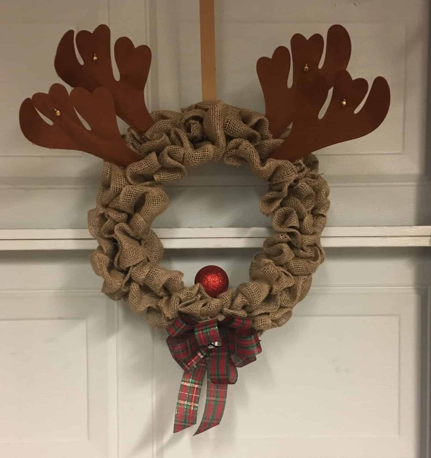 Rudolph-themed burlap Christmas wreath with antlers, red nose, and plaid bow