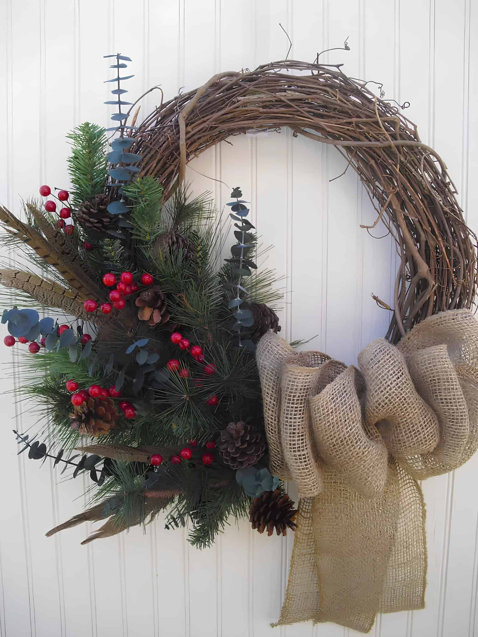 Rustic wooden grapevine wreath with burlap bow, eucalyptus, pine and red berries