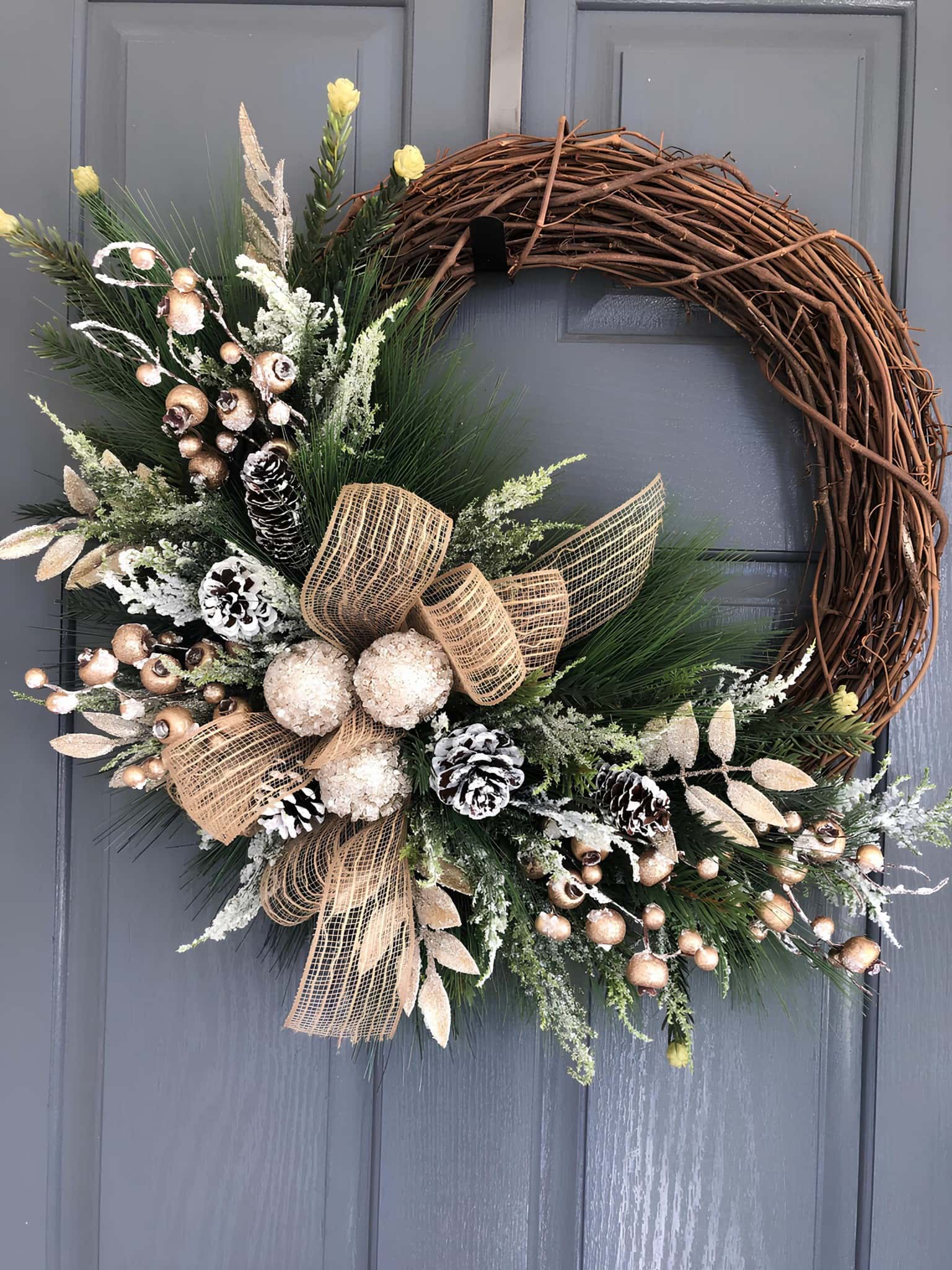 Elegant wooden grapevine Christmas wreath with frosted pinecones, champagne accents and a burlap bow