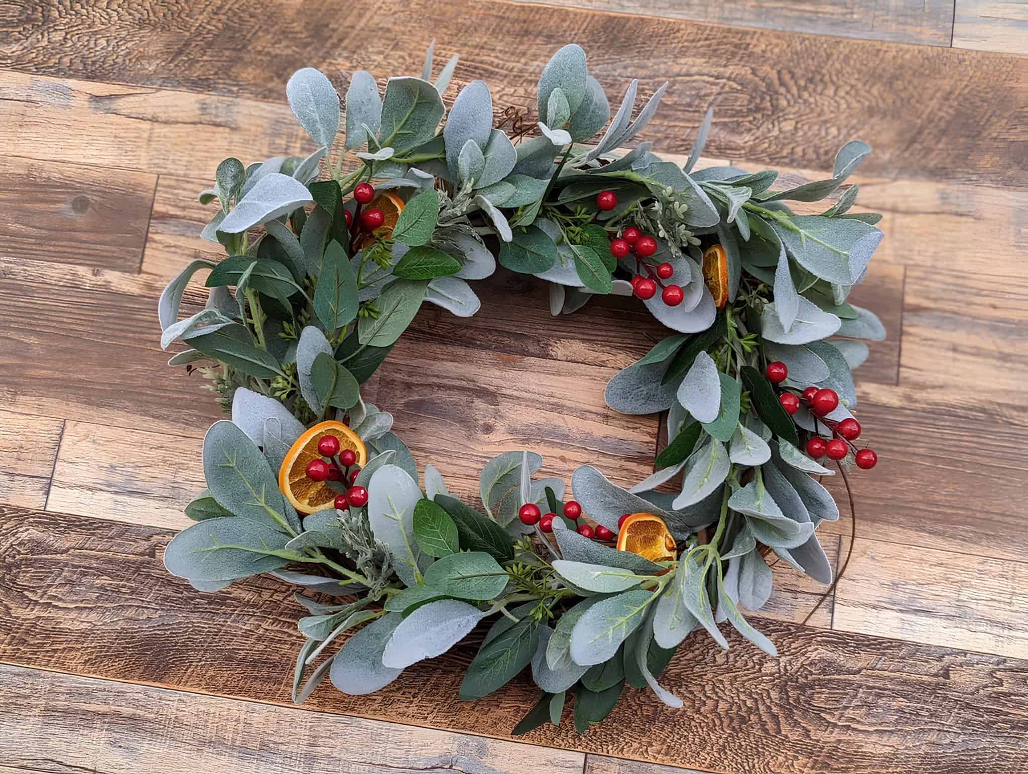 Christmas wreath with sage eucalyptus, red berries, and dried orange slices