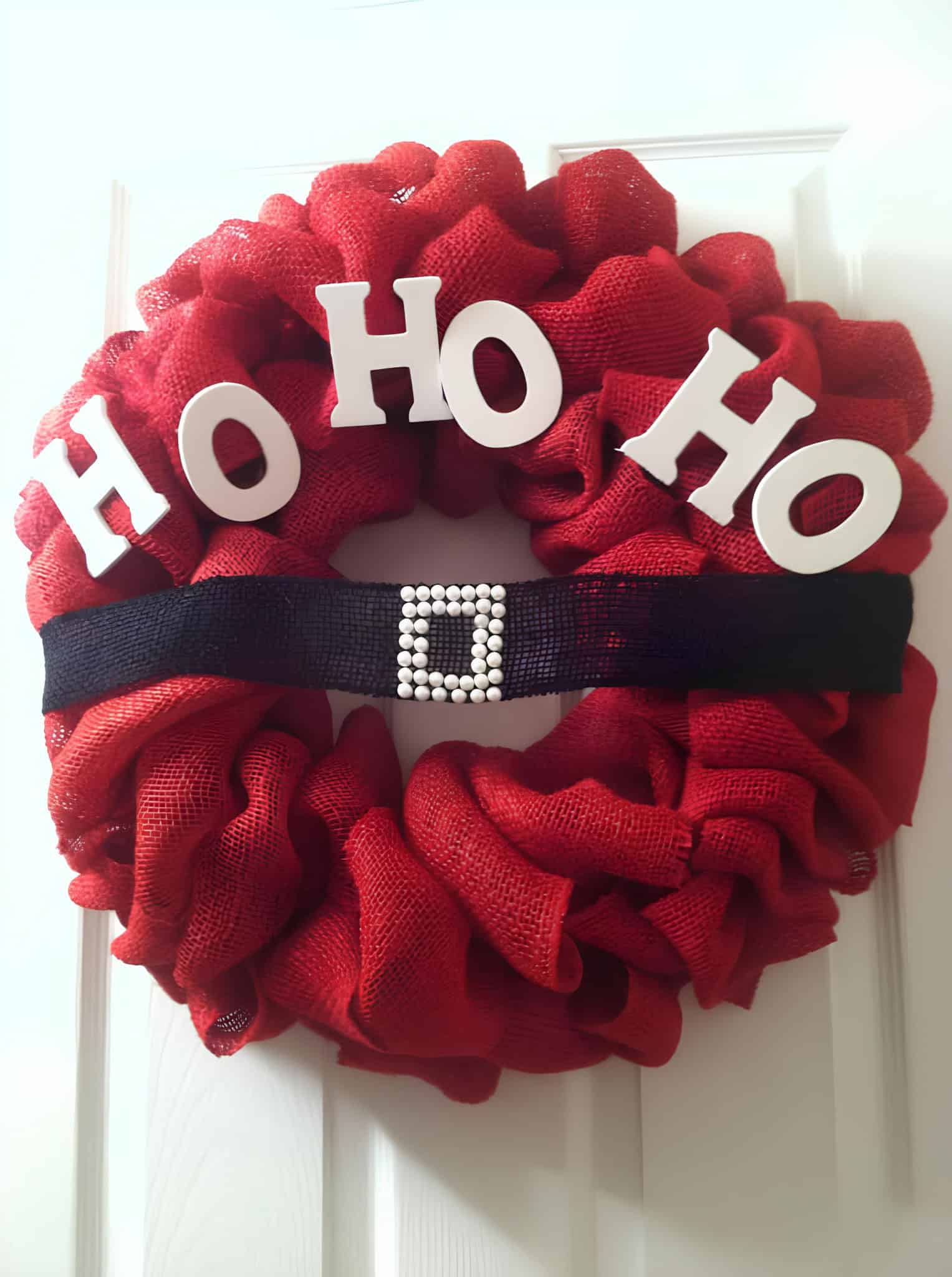 Red burlap wreath with HO HO HO letters and a black Santa belt with buckle