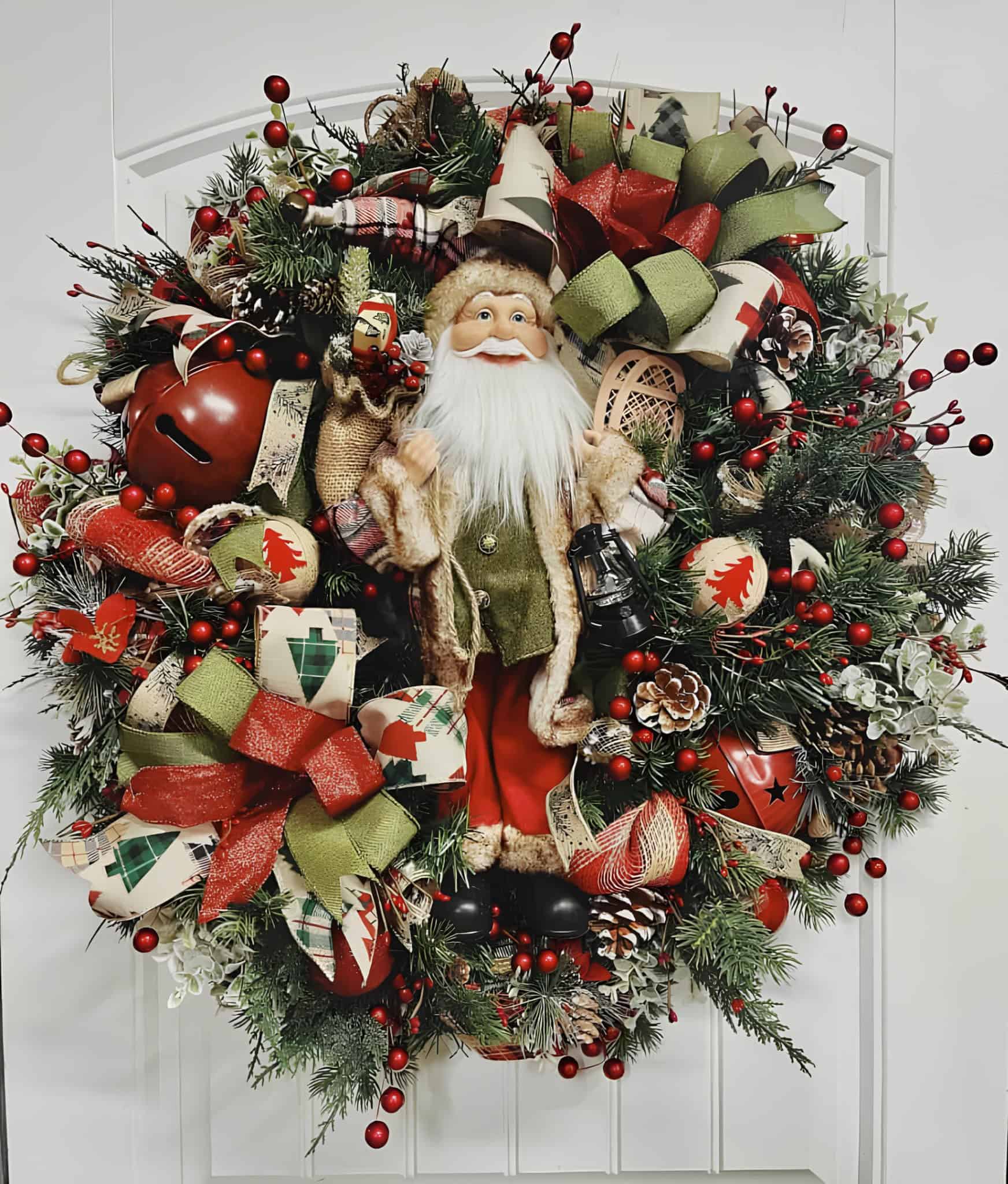 Festive Christmas wreath with Santa figurine, pinecones, red berries, holiday ribbons, and evergreen branches, perfect for holiday Christmas decor and Christmas home decoration.