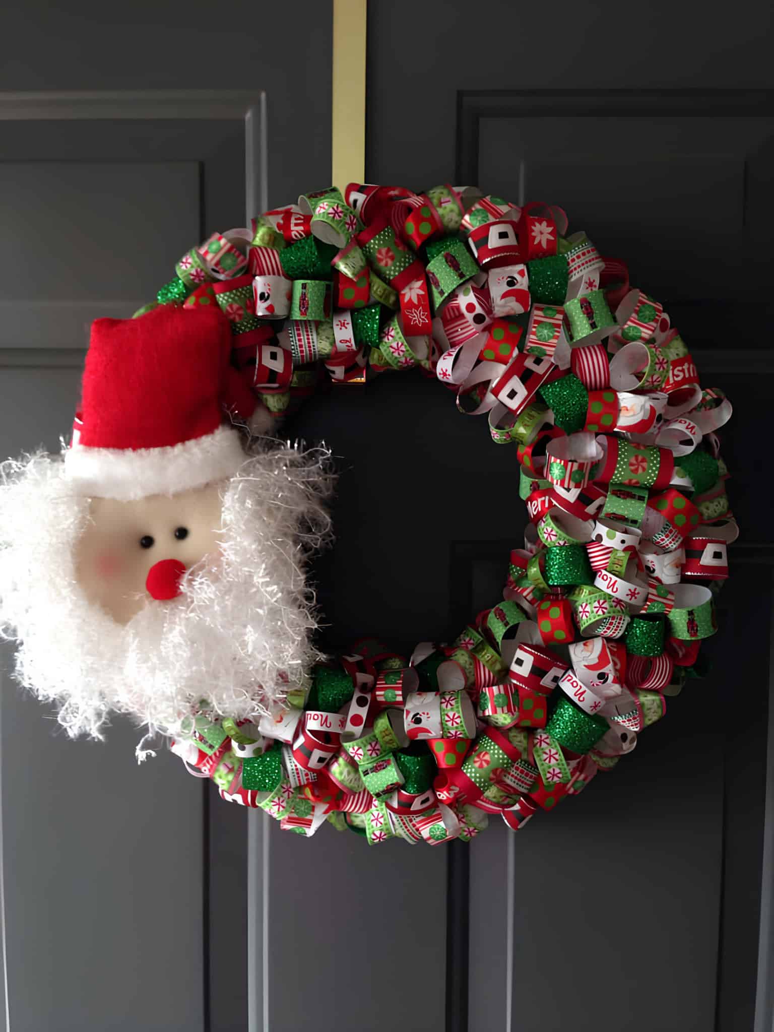 Festive Christmas wreath with Santa head and colorful ribbons