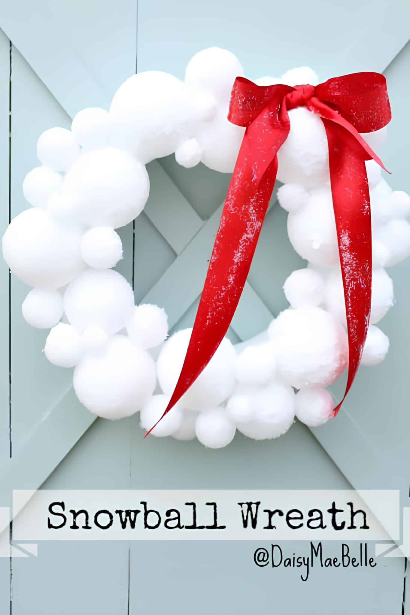 Snowball wreath made of cotton balls with a large red bow, perfect for winter holiday decor or Christmas ornament centerpiece.