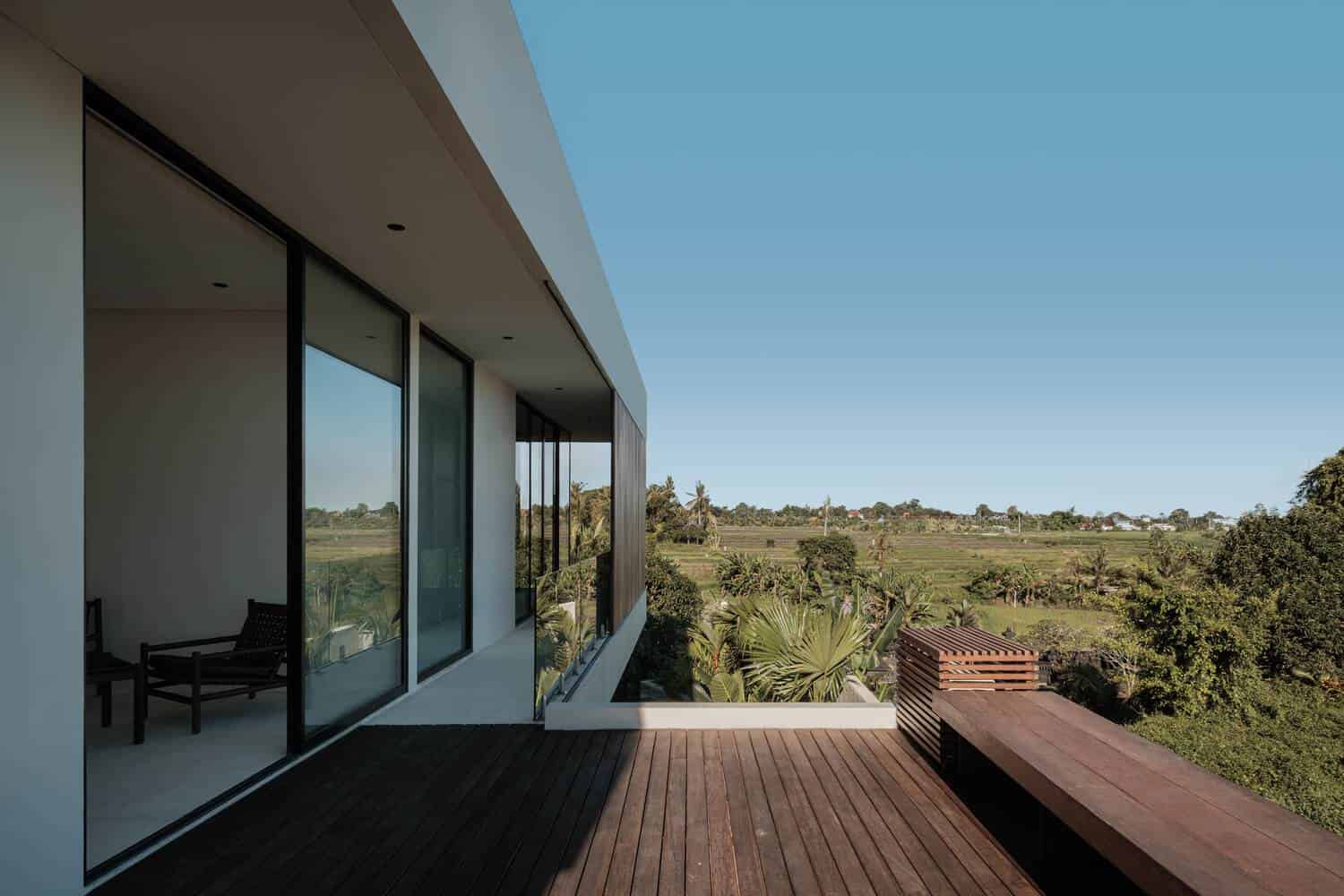 Tapa Villa Terrace View Two by Studio Tanama Tapa Villa by Studio Tanama terrace with glass railing and panoramic rice field view in Bali, Indonesia
