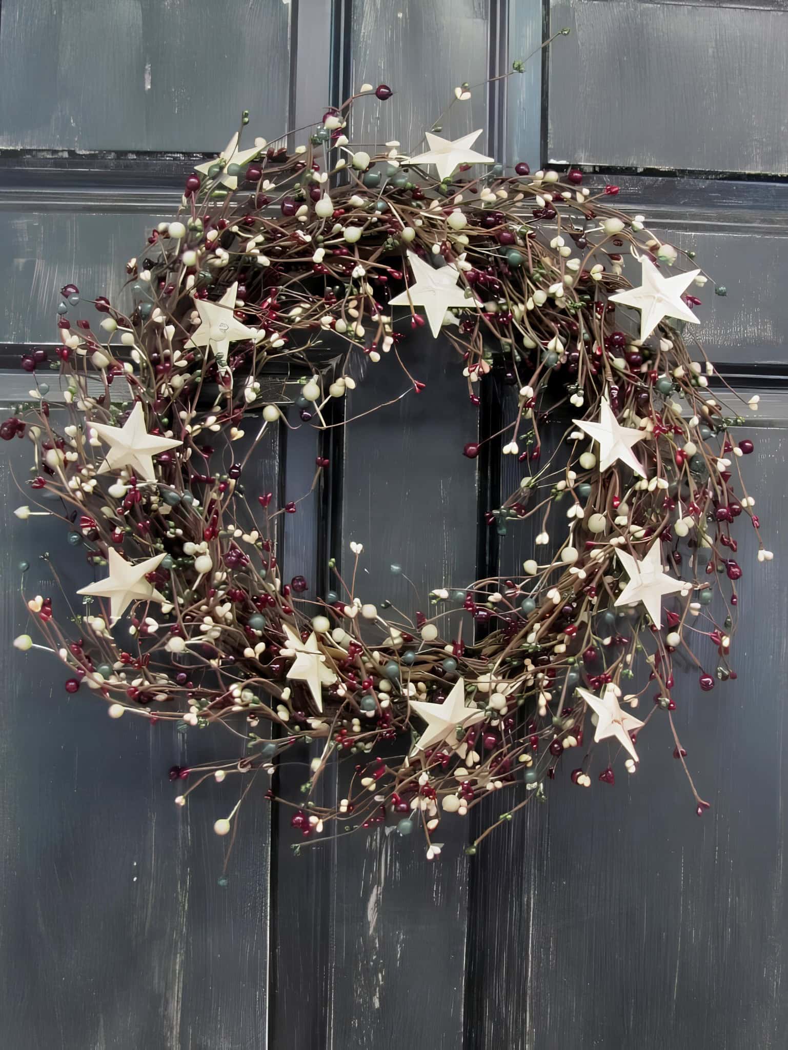 Rustic twig Christmas wreath decorated with white stars and red berries