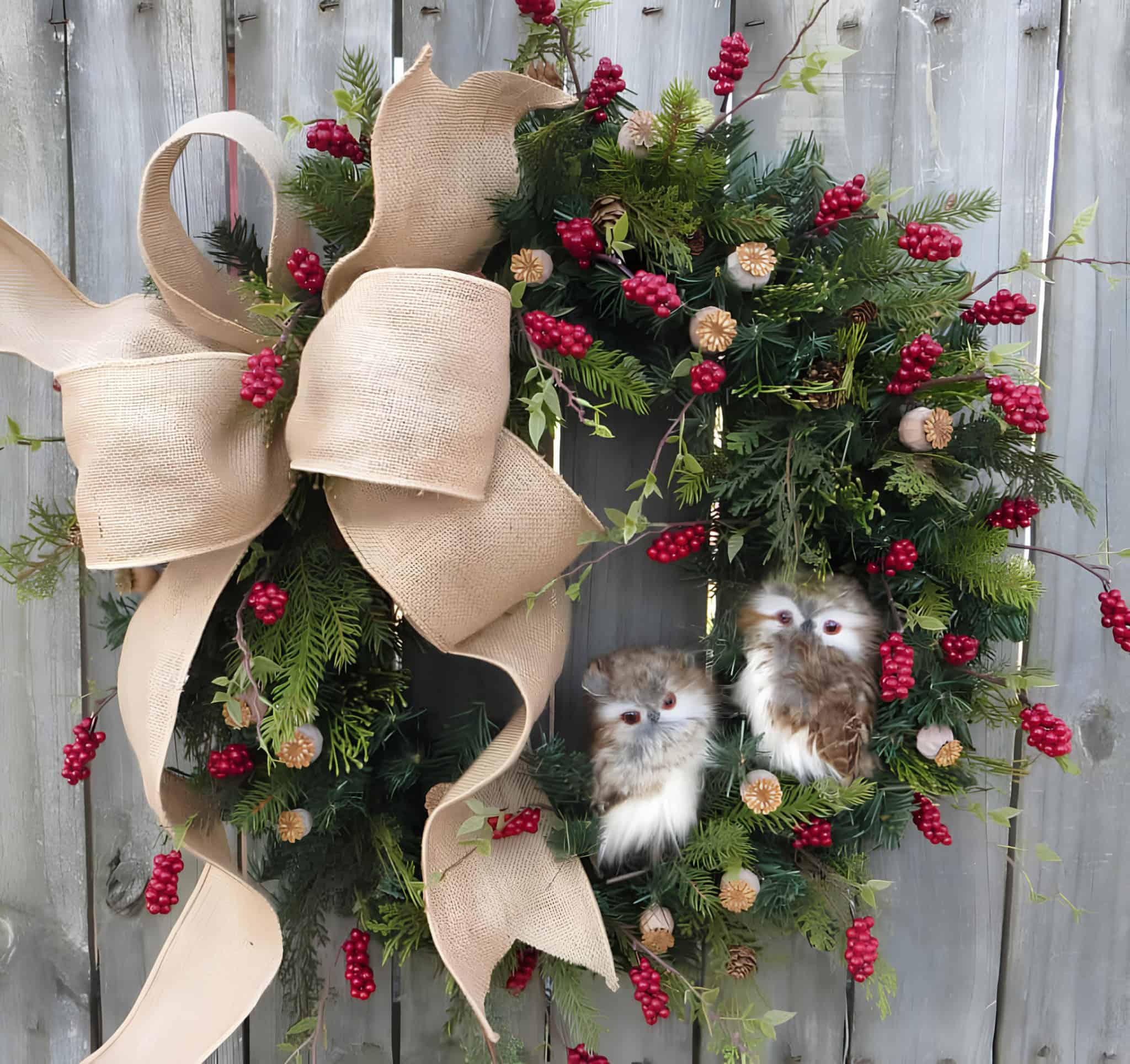 Evergreen Christmas wreath with burlap bow, red berries and two owl ornaments