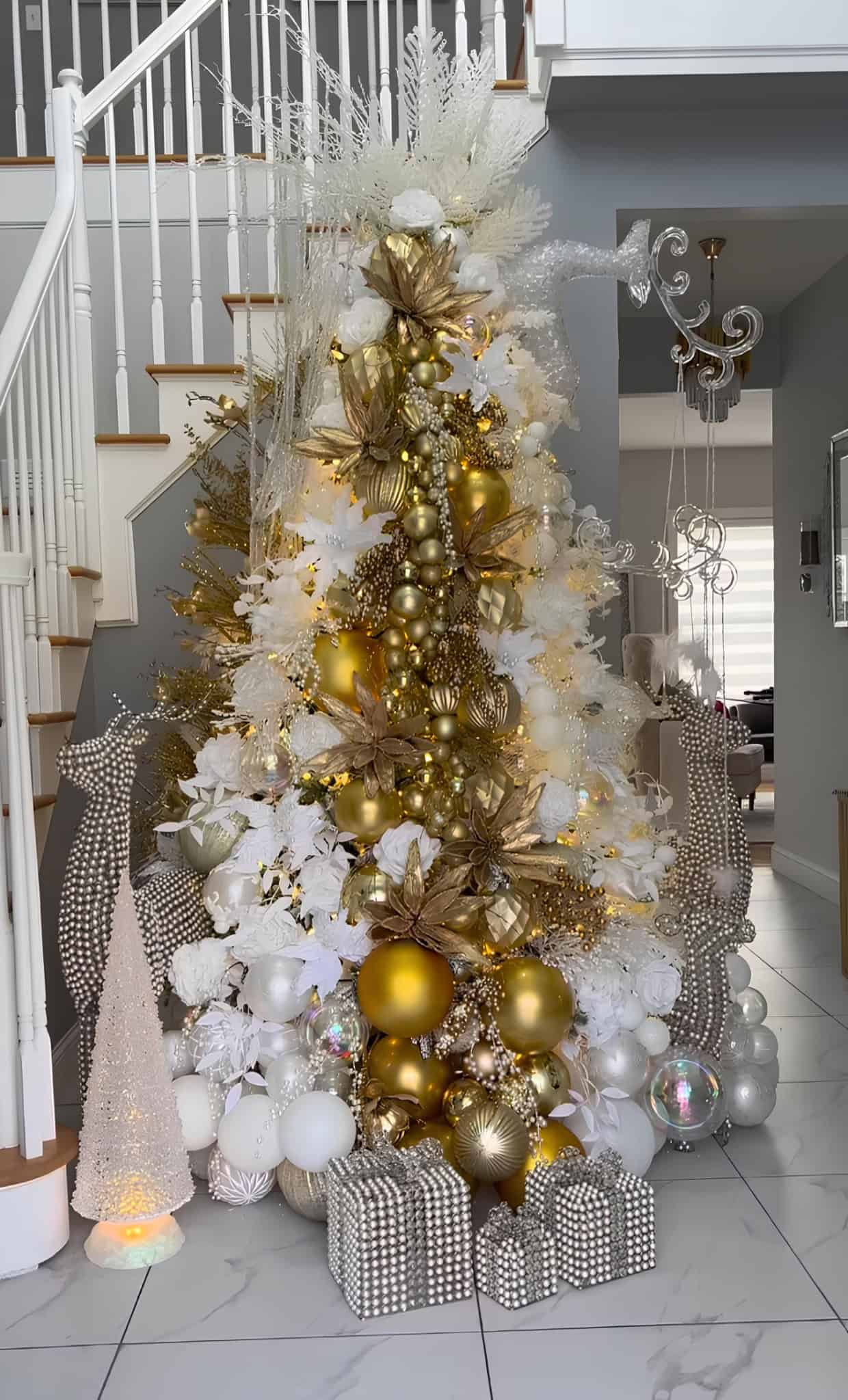 White and gold Christmas tree with metallic ornaments and shimmering accents