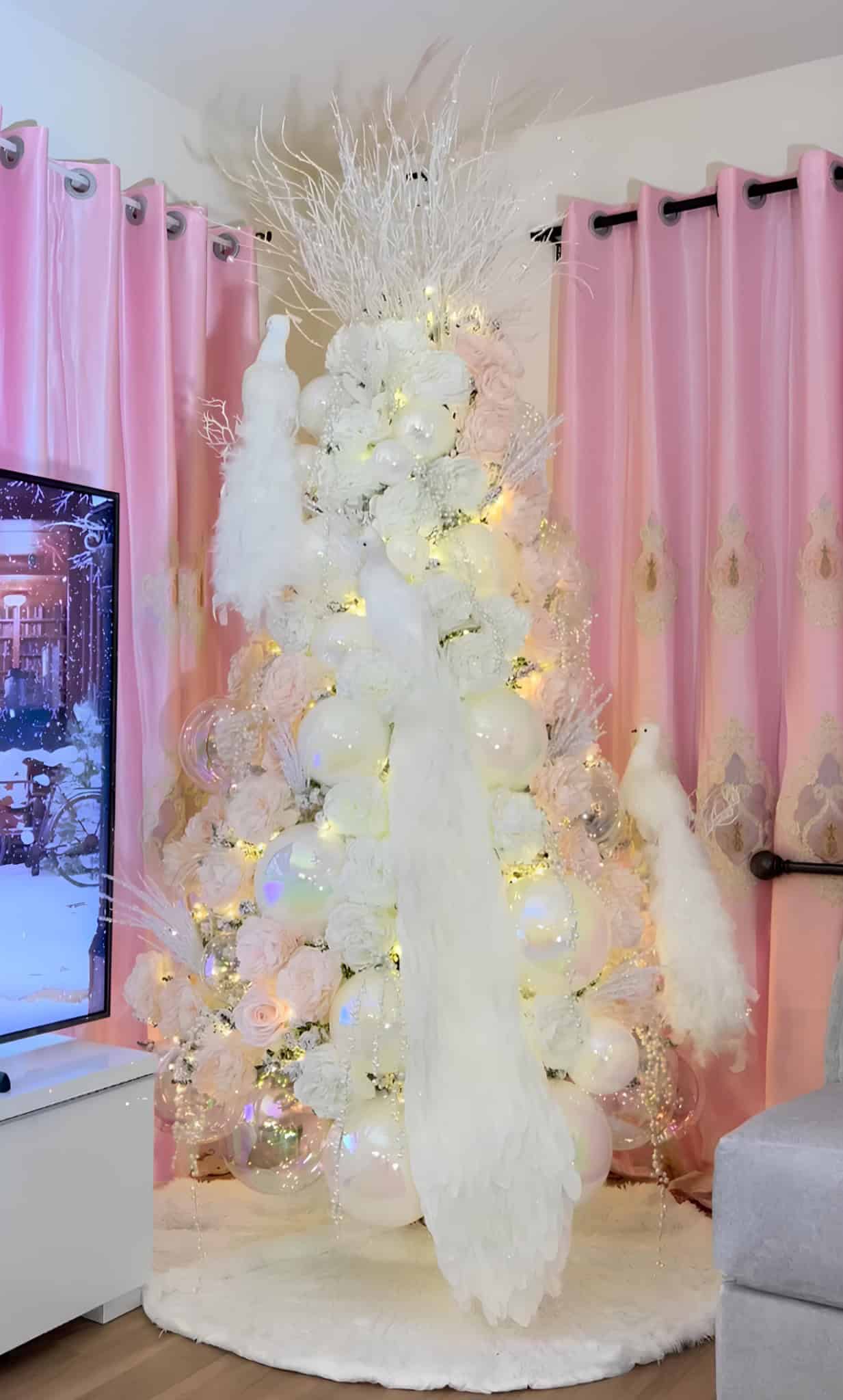 White and blush pink Christmas tree with peacock ornaments and floral details