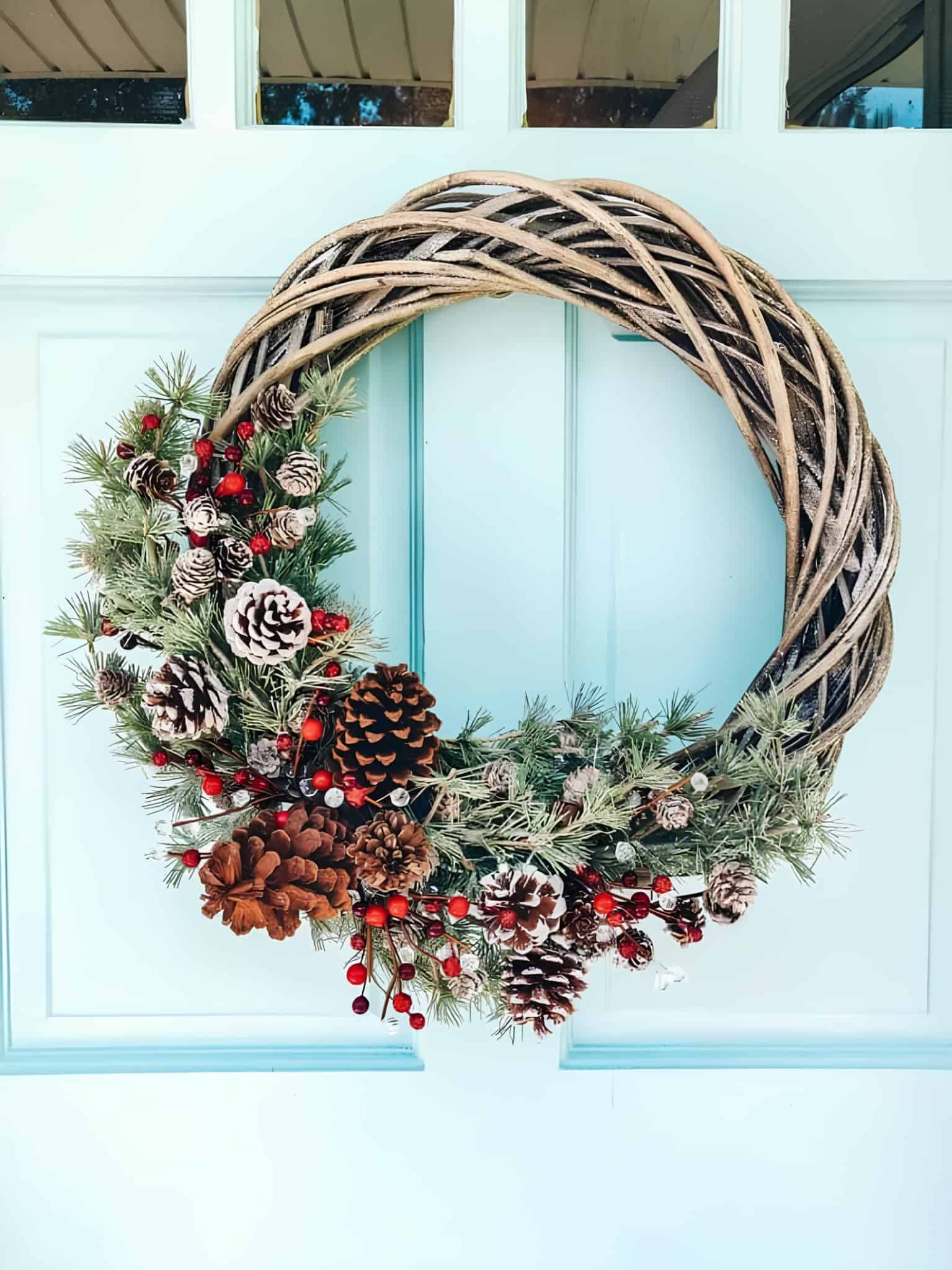 Half-covered wooden wreath with frosted pinecones and red berries on a twisted grapevine base