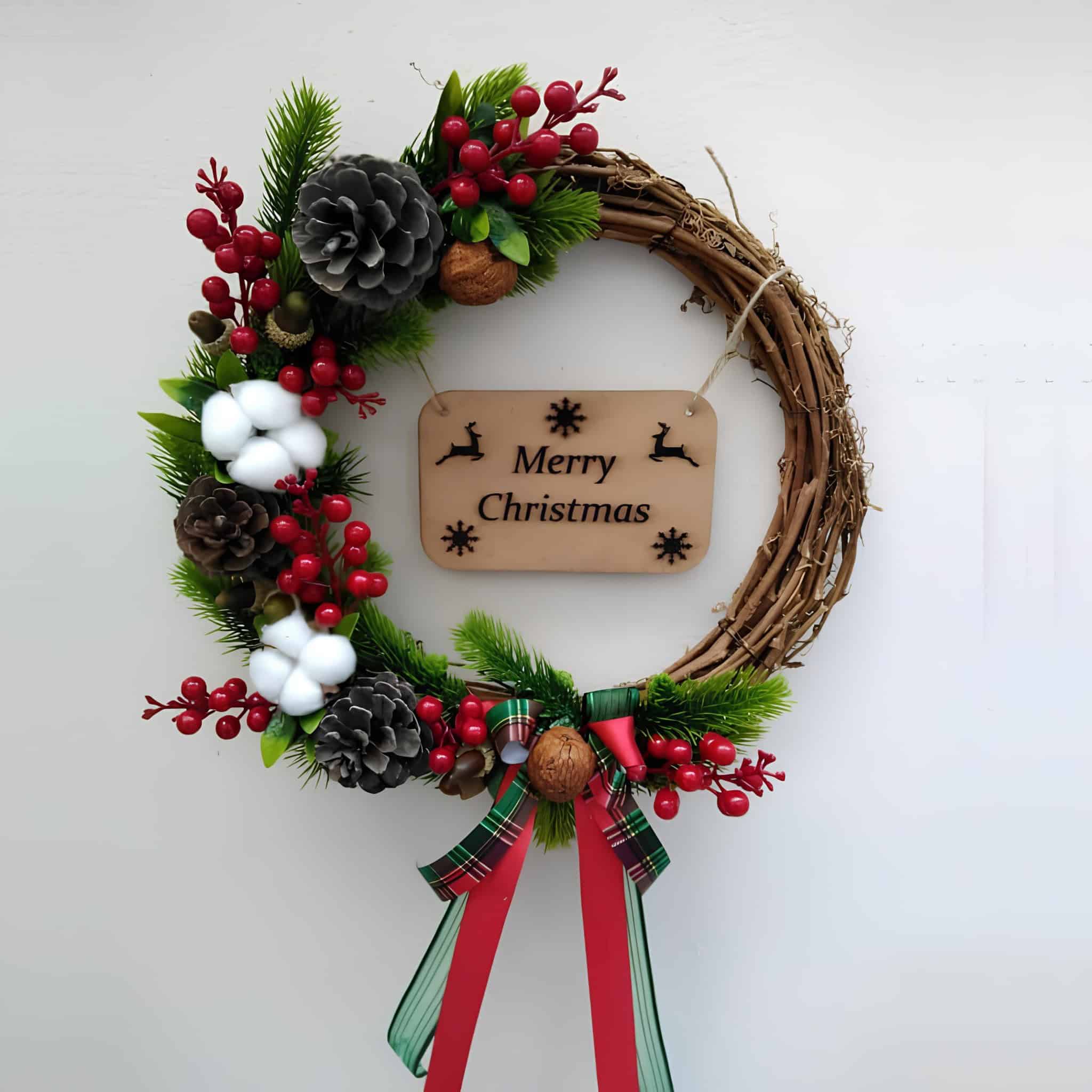 Minimal wooden grapevine wreath with Merry Christmas plaque, red berries, cotton bolls and pinecones