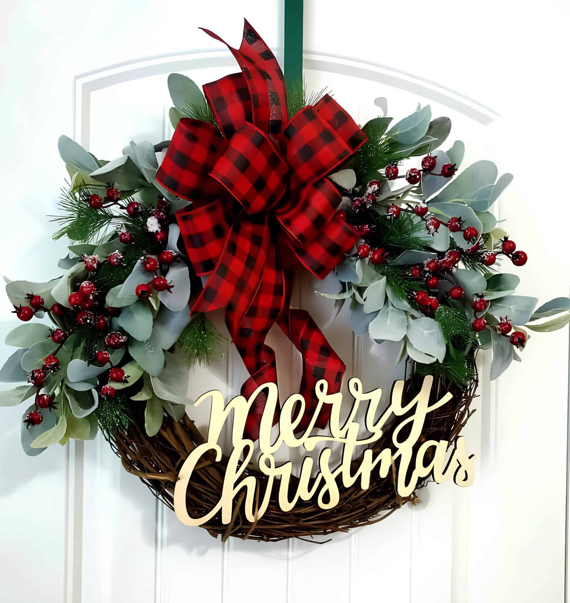 Wooden grapevine wreath with eucalyptus, red berries, buffalo plaid bow and Merry Christmas sign
