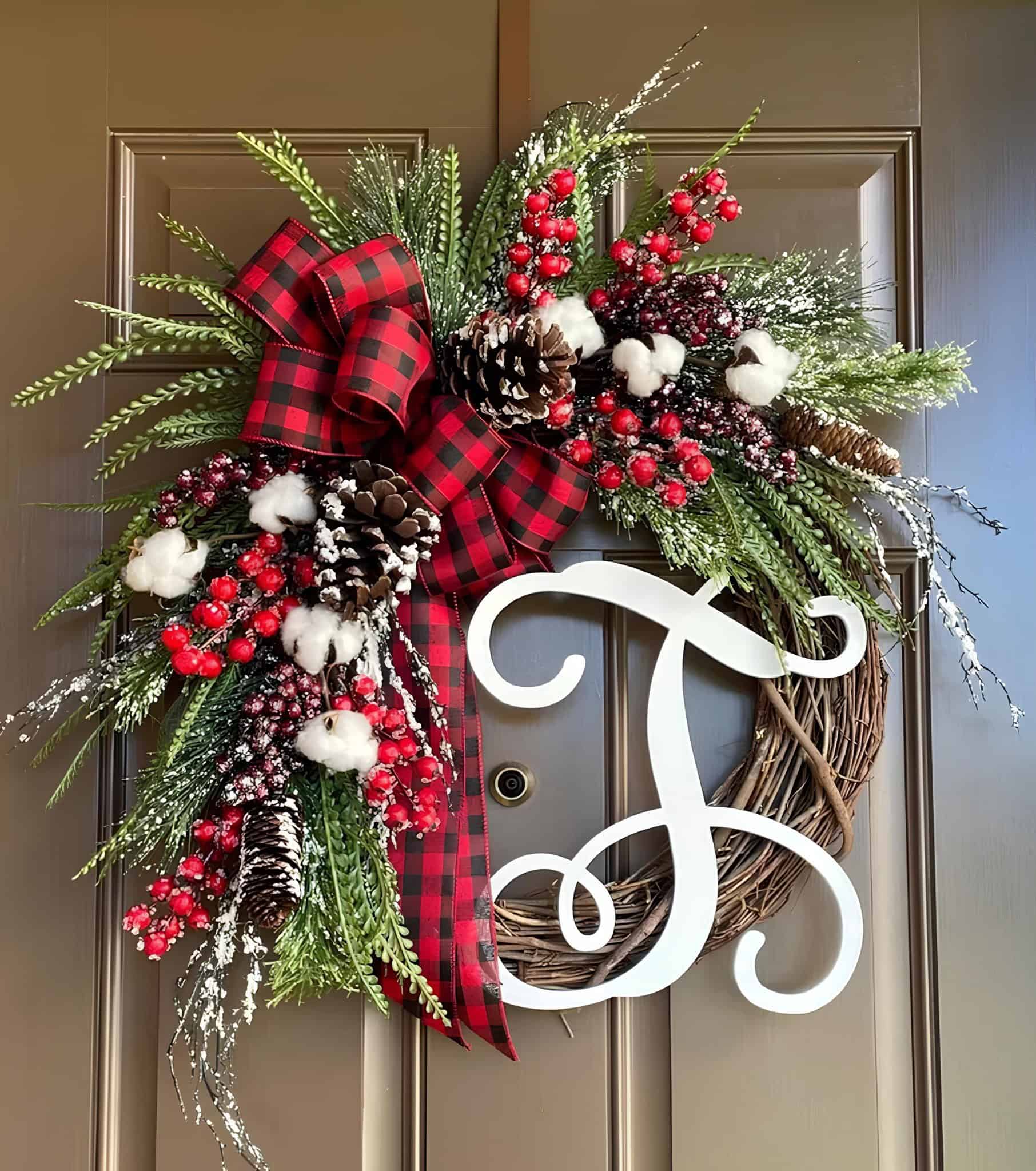 Wooden monogram grapevine Christmas wreath with buffalo plaid bow, cotton bolls, pinecones and red berries