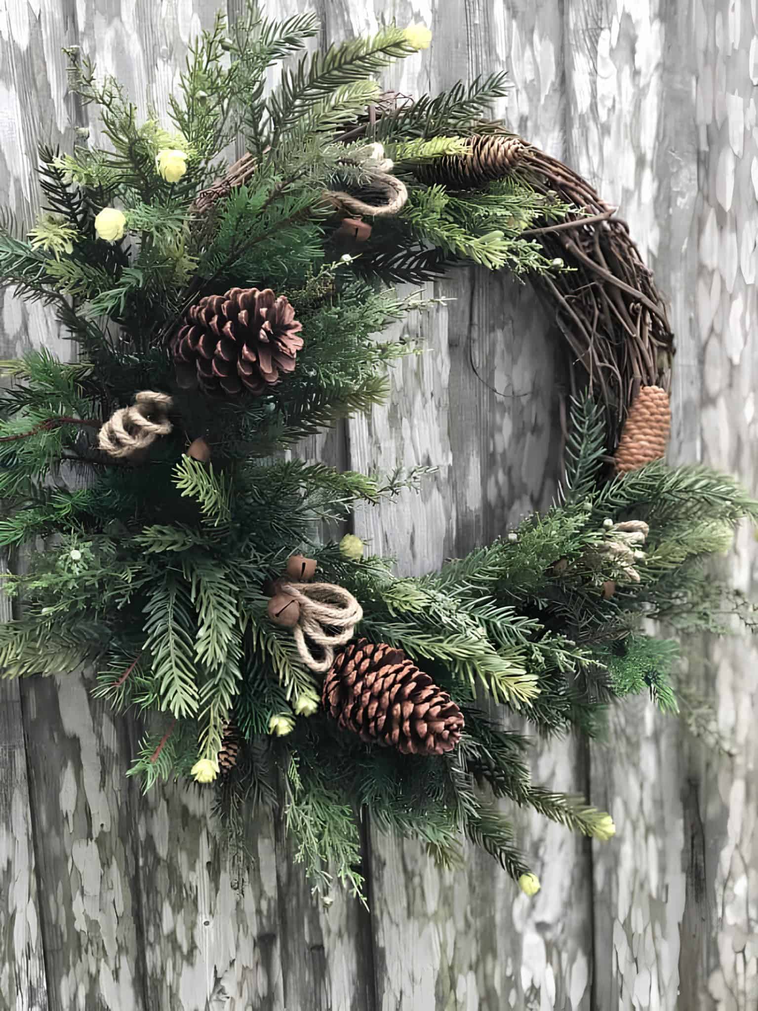 Natural wooden grapevine wreath with large pinecones, twine bells and lush evergreen sprigs