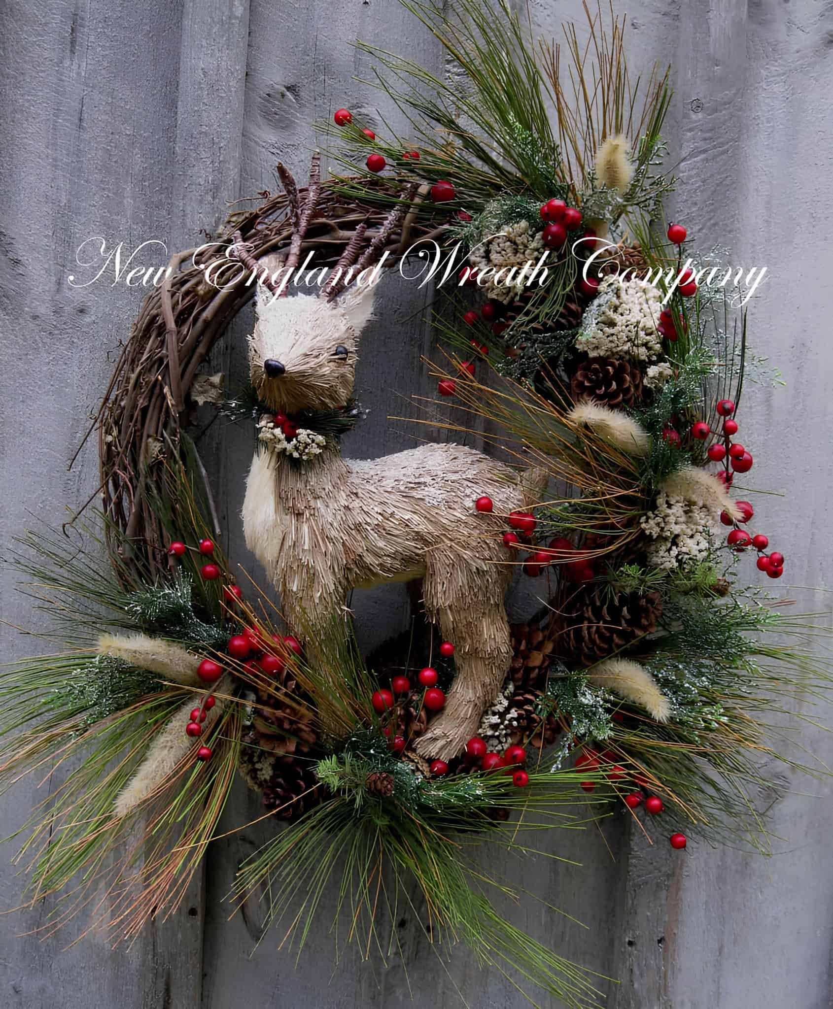 Wooden woodland reindeer on a grapevine wreath with red berries, pine needles and cones